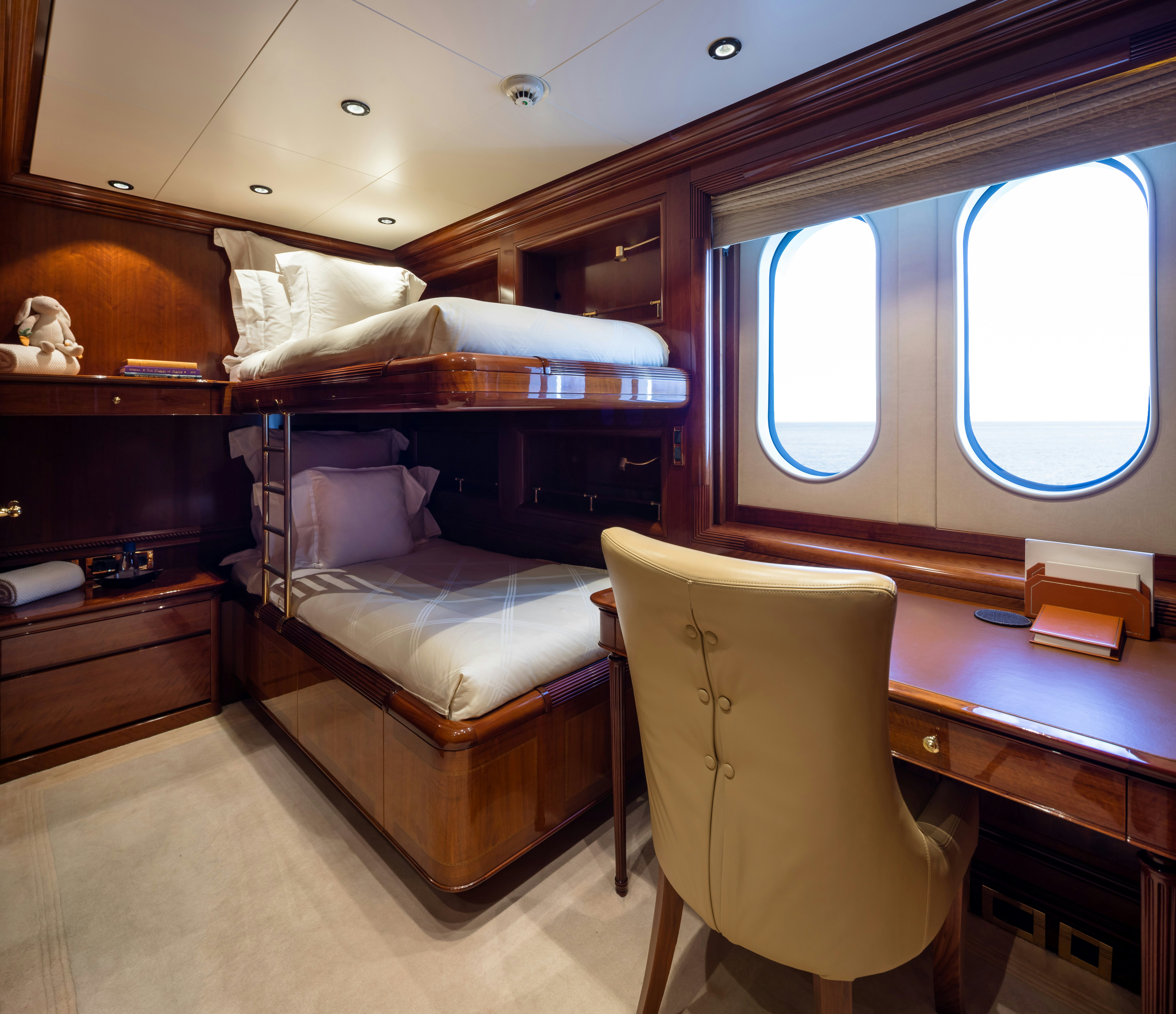 a room with a bed and a chair aboard STARFIRE Yacht for Charter
