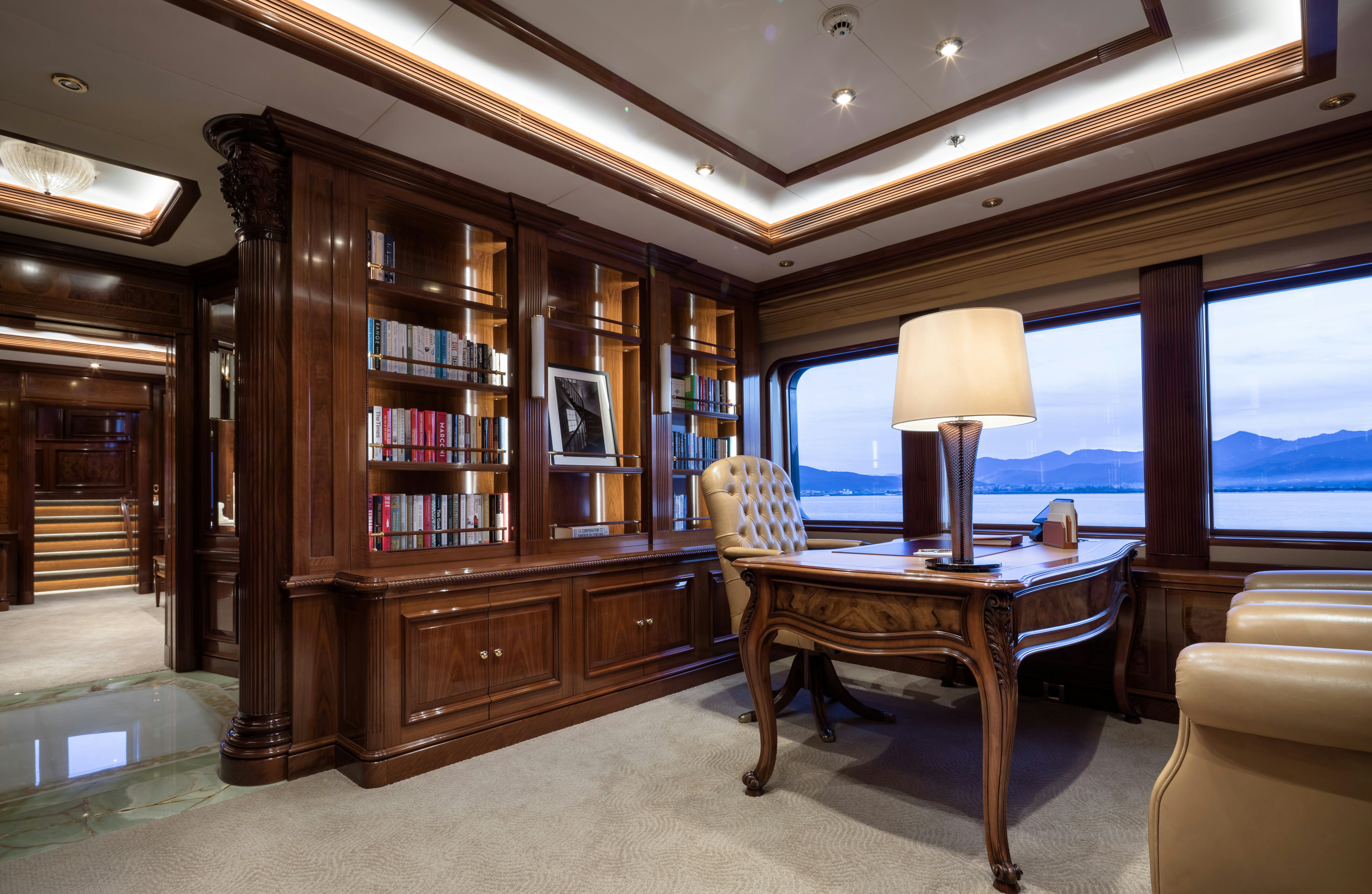 a room with a table and a bookcase aboard STARFIRE Yacht for Charter
