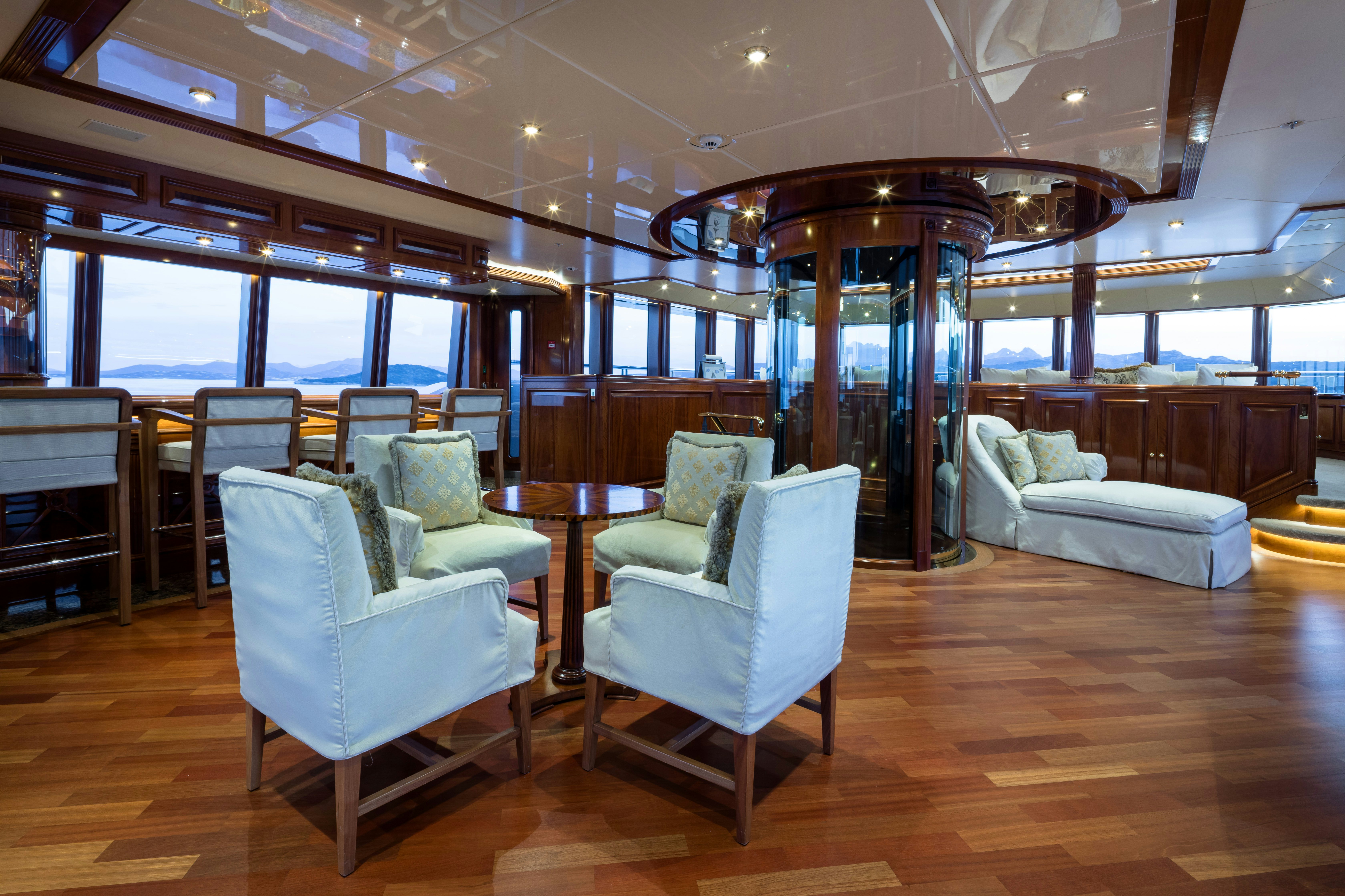 a room with chairs and tables aboard STARFIRE Yacht for Charter