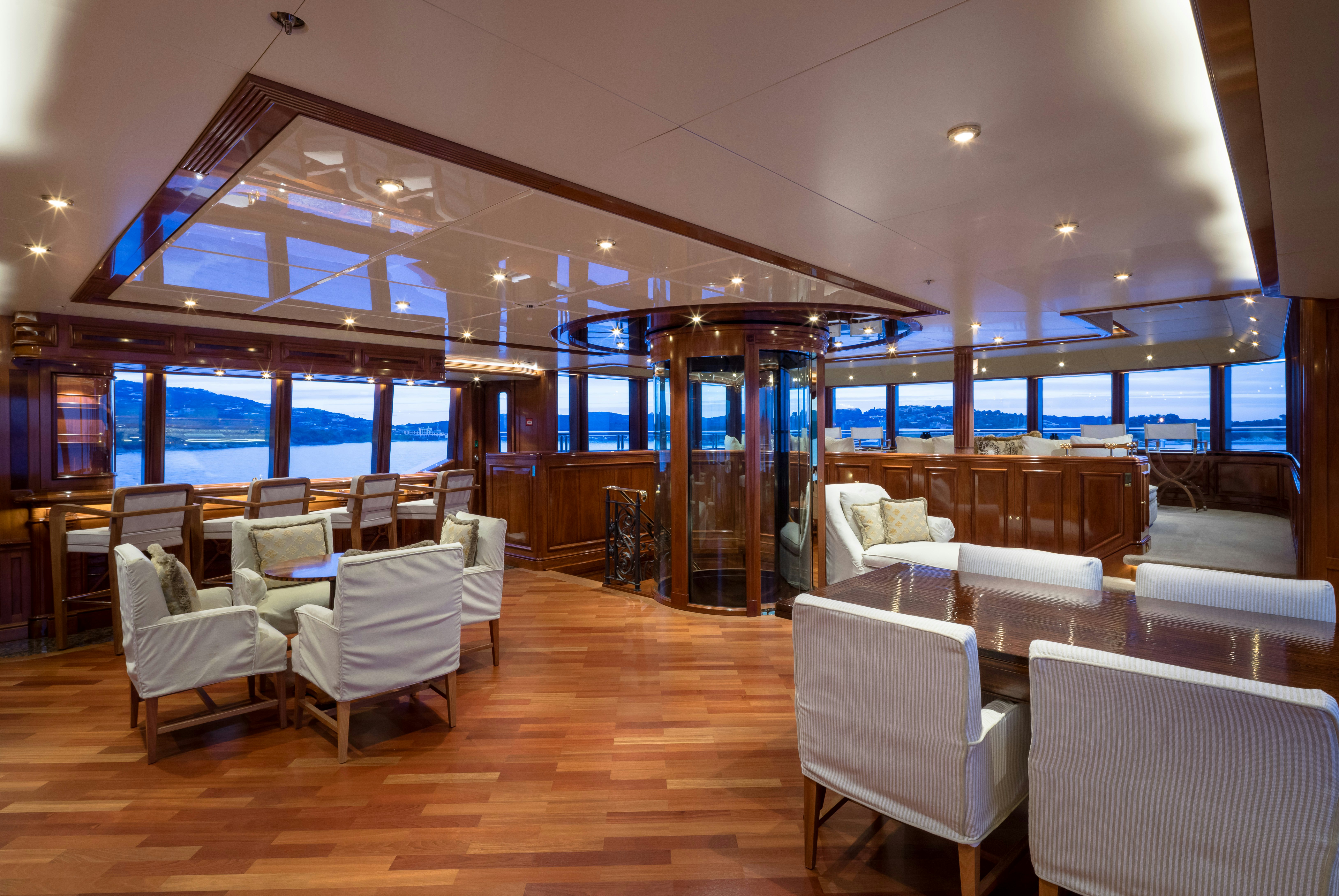 a room with a bar and chairs aboard STARFIRE Yacht for Charter