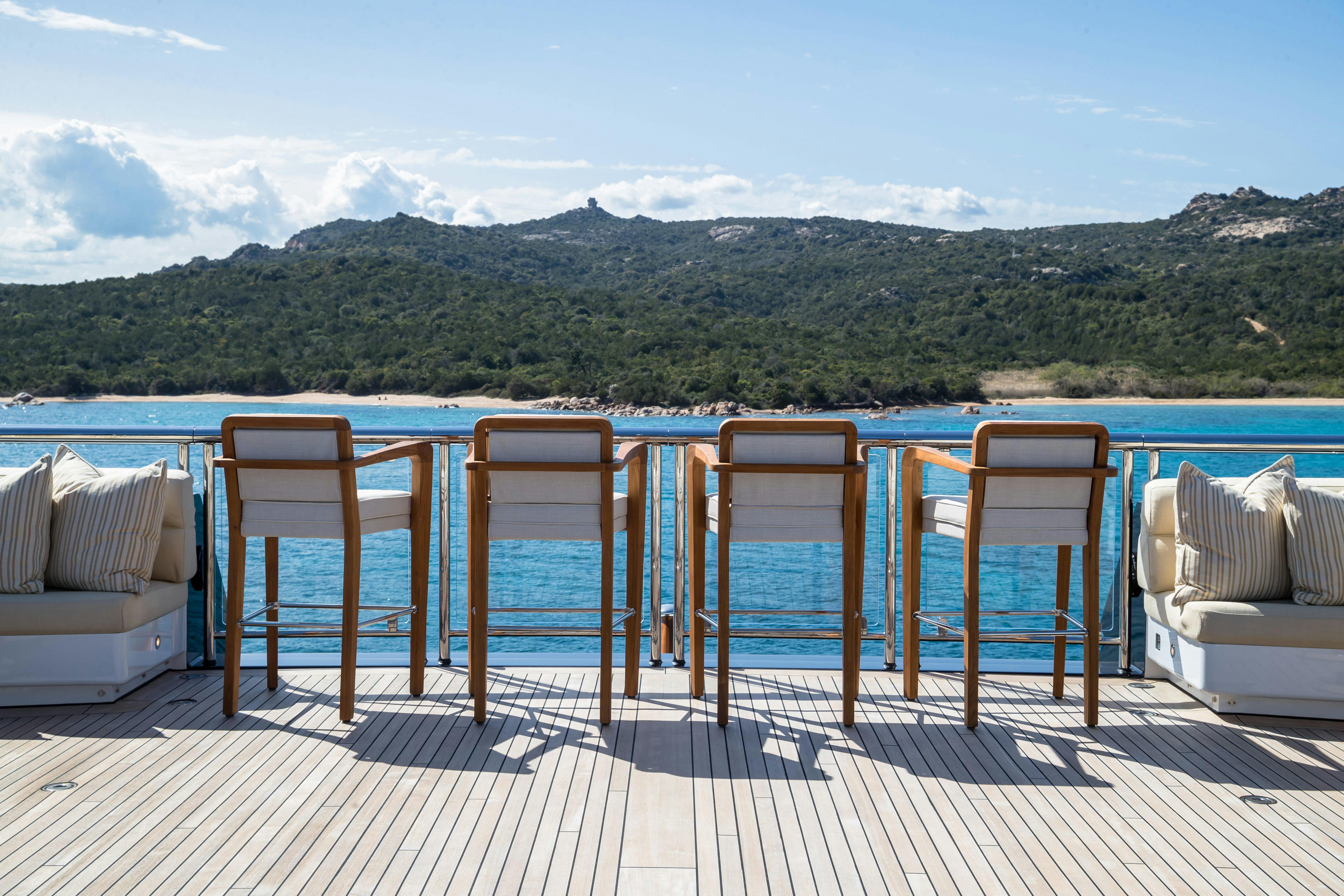 a deck with chairs and a body of water in the background aboard STARFIRE Yacht for Charter