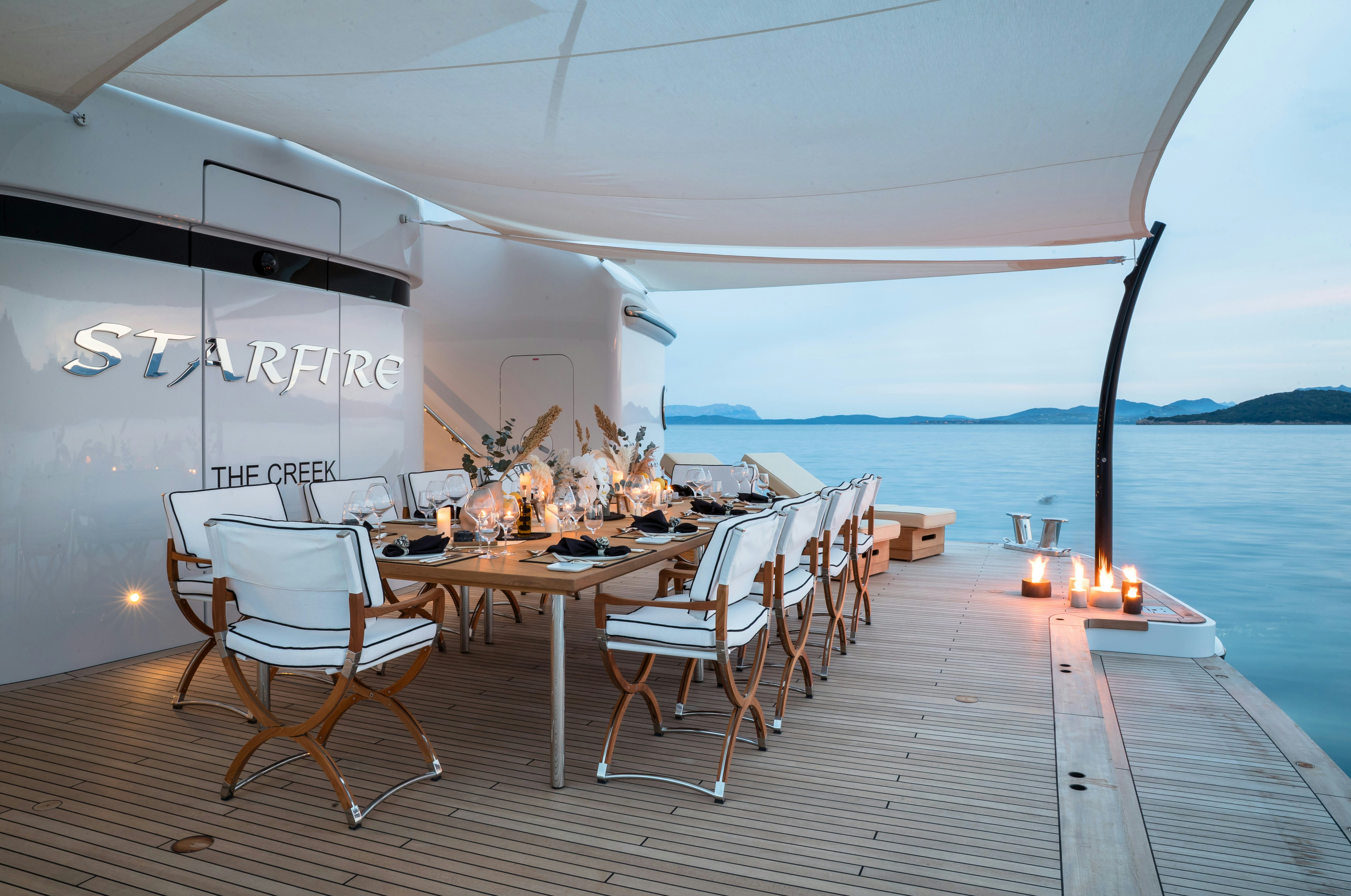 a table and chairs on a deck aboard STARFIRE Yacht for Charter