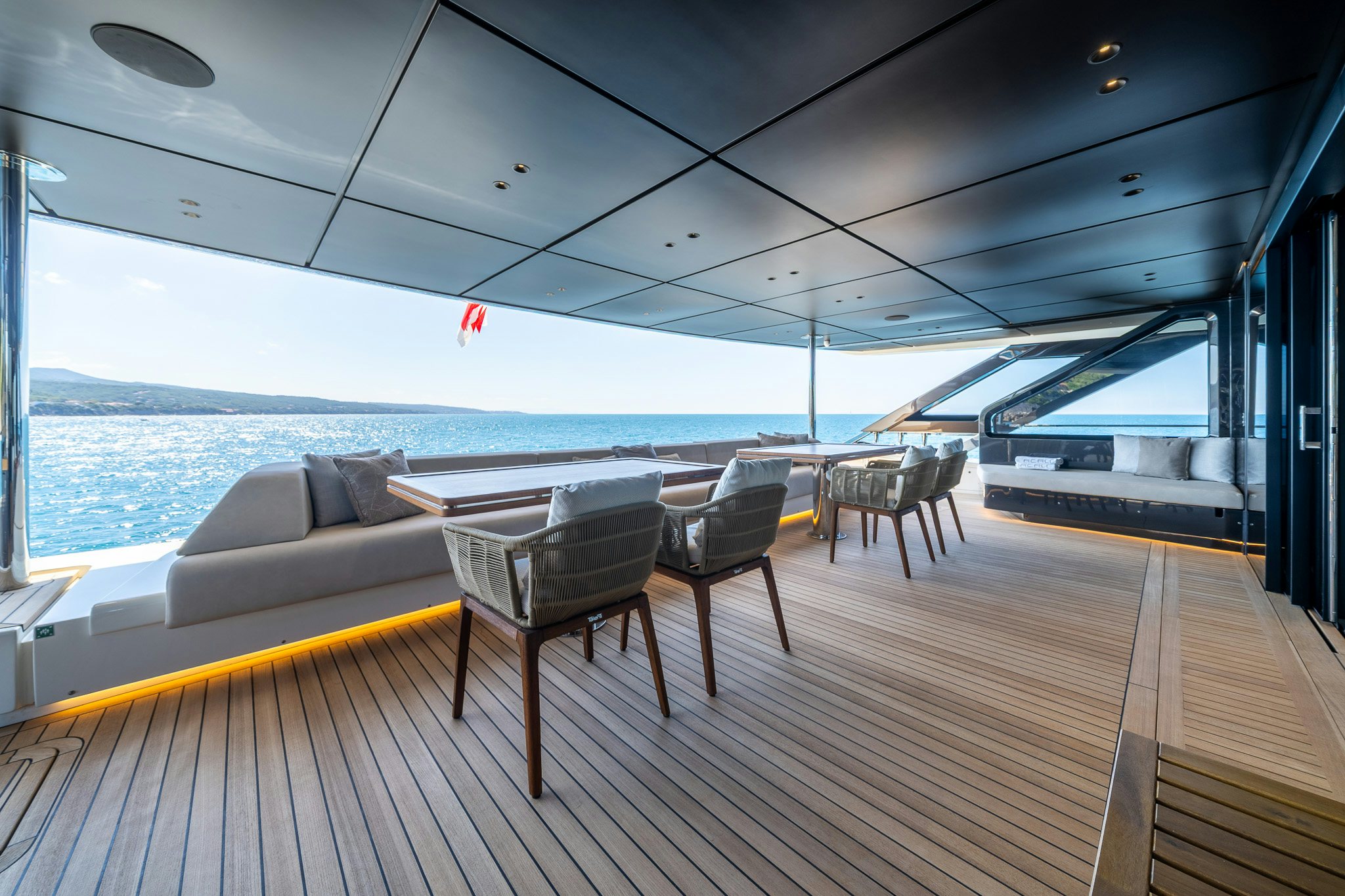 a deck with chairs and a table on it aboard ACALI Yacht for Sale