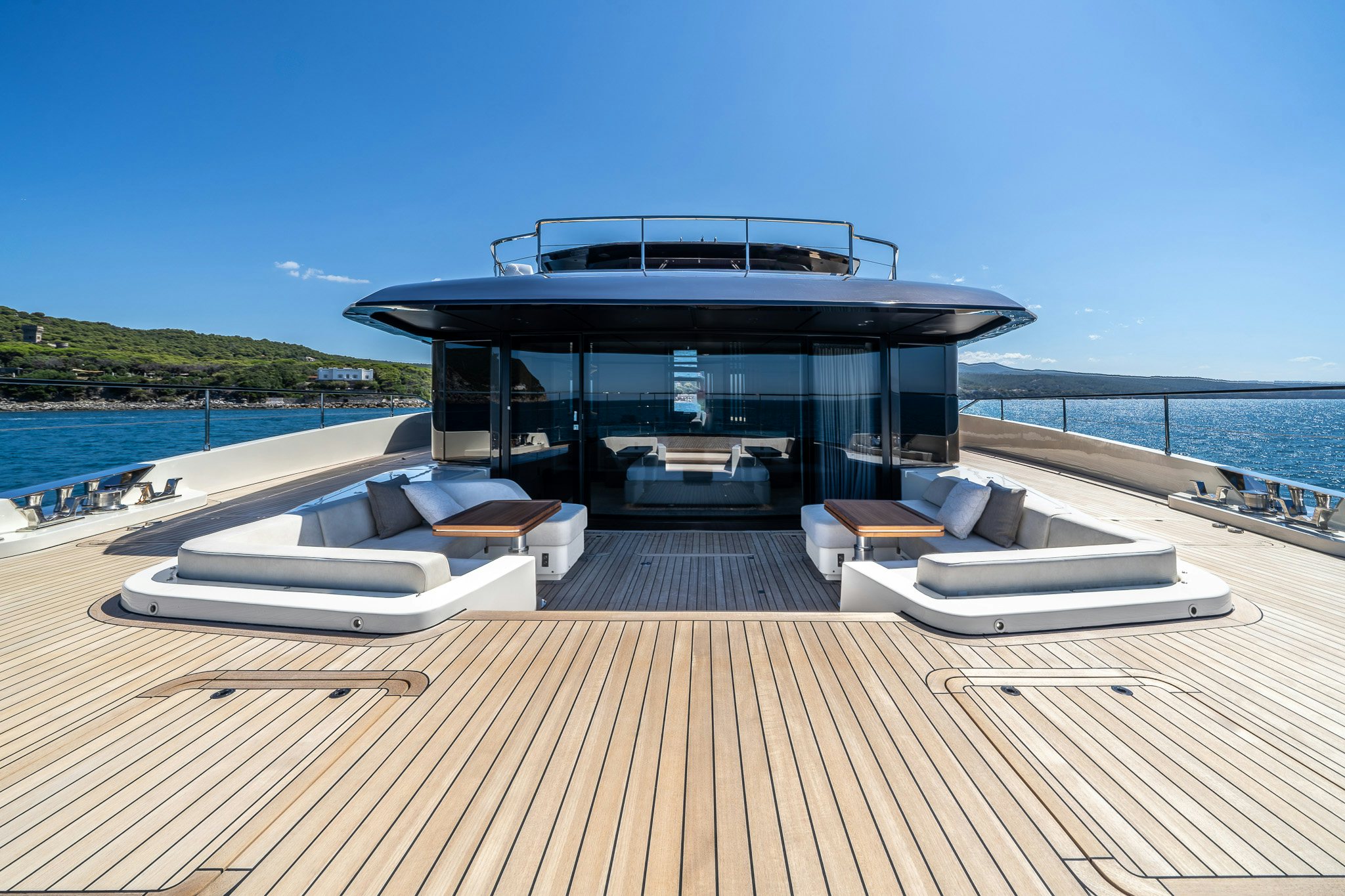 a deck with a large pool and a large house on the water aboard ACALI Yacht for Sale