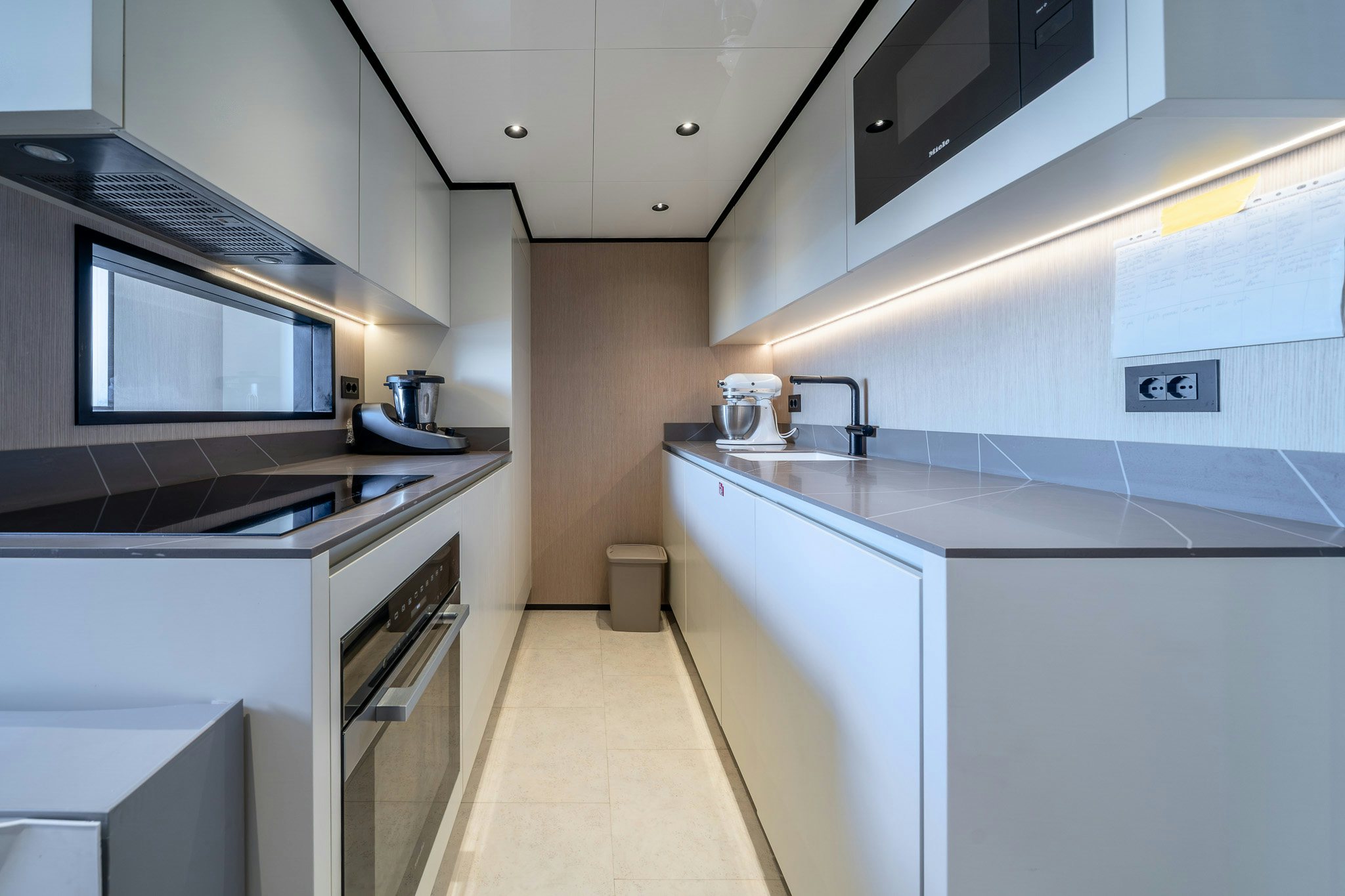 a kitchen with white cabinets aboard ACALI Yacht for Sale