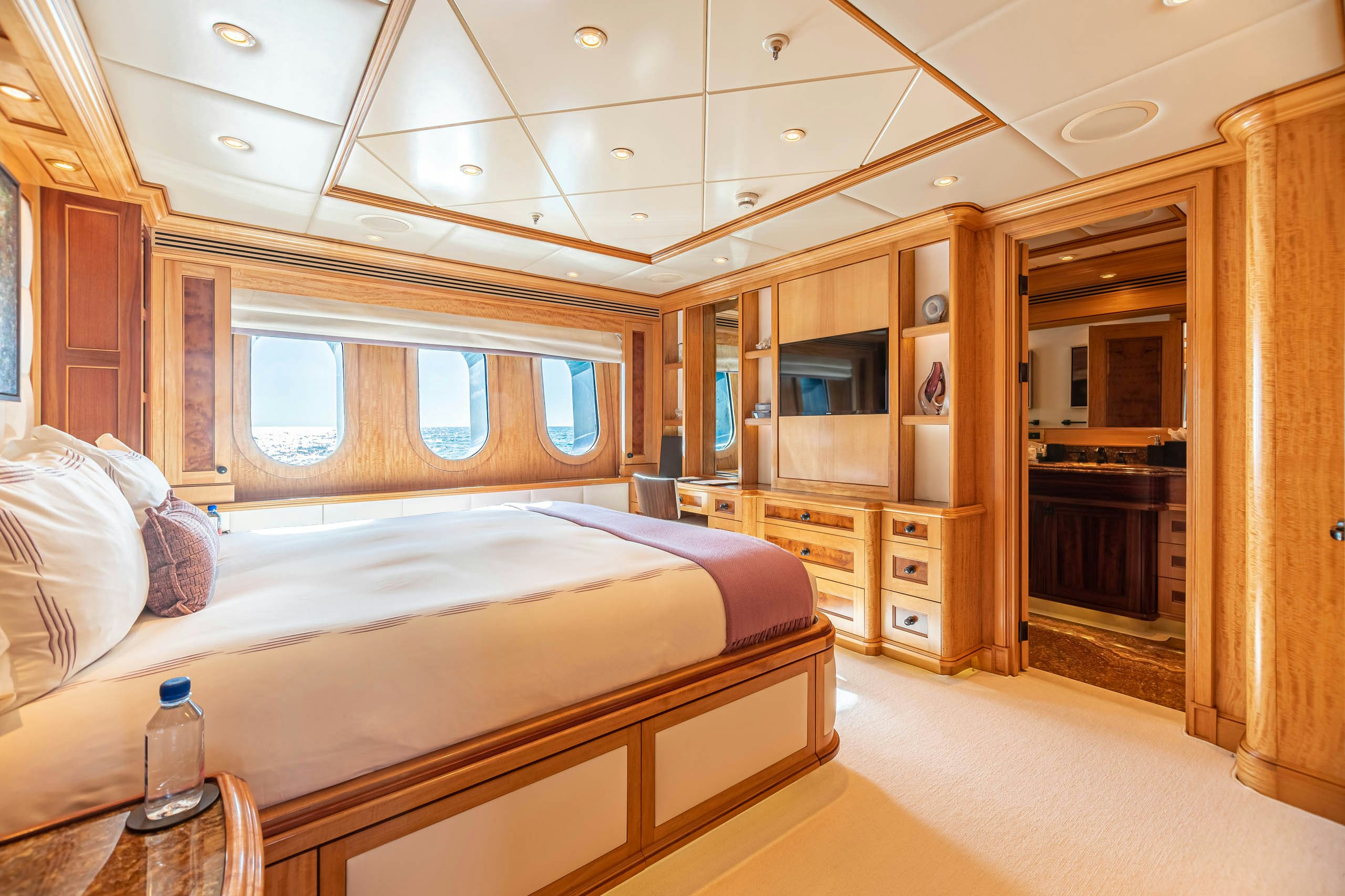 a bedroom with a bed and a wood cabinet aboard UNBRIDLED Yacht for Charter