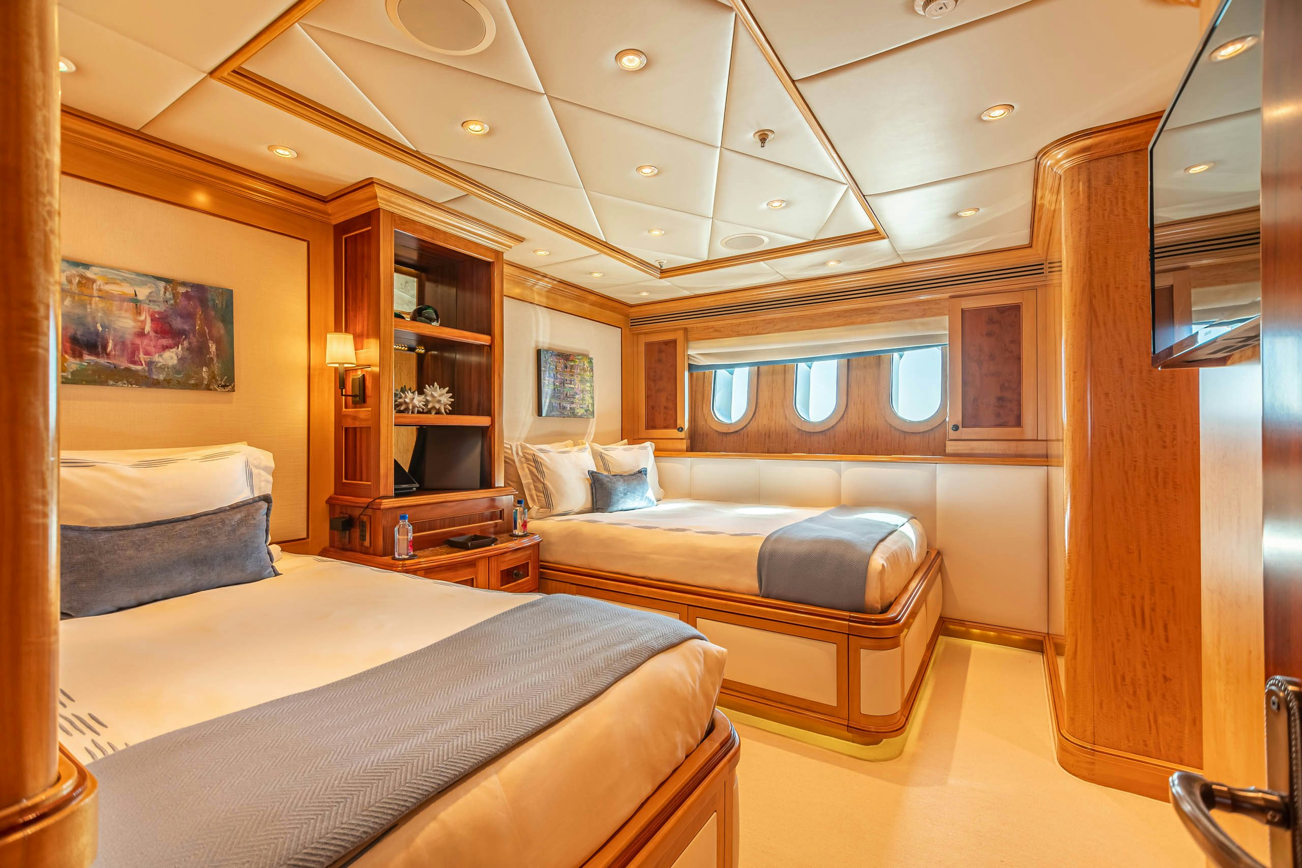 a room with a bed and a bookcase aboard UNBRIDLED Yacht for Charter