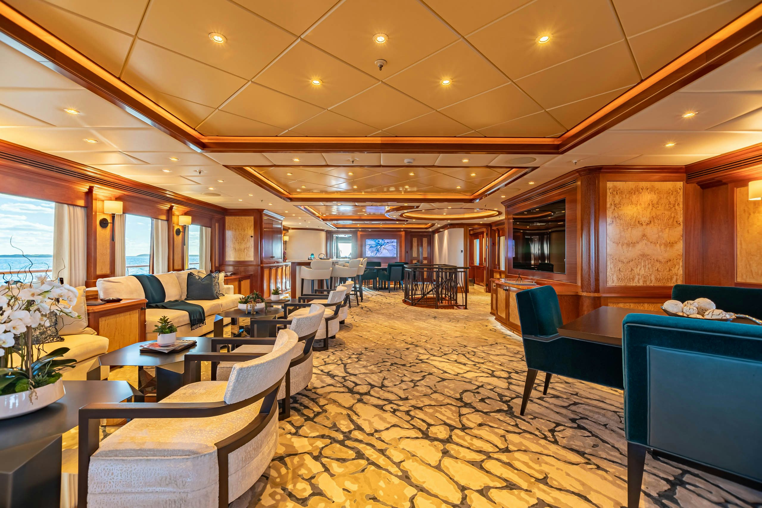 a room with a table chairs and a television aboard UNBRIDLED Yacht for Charter