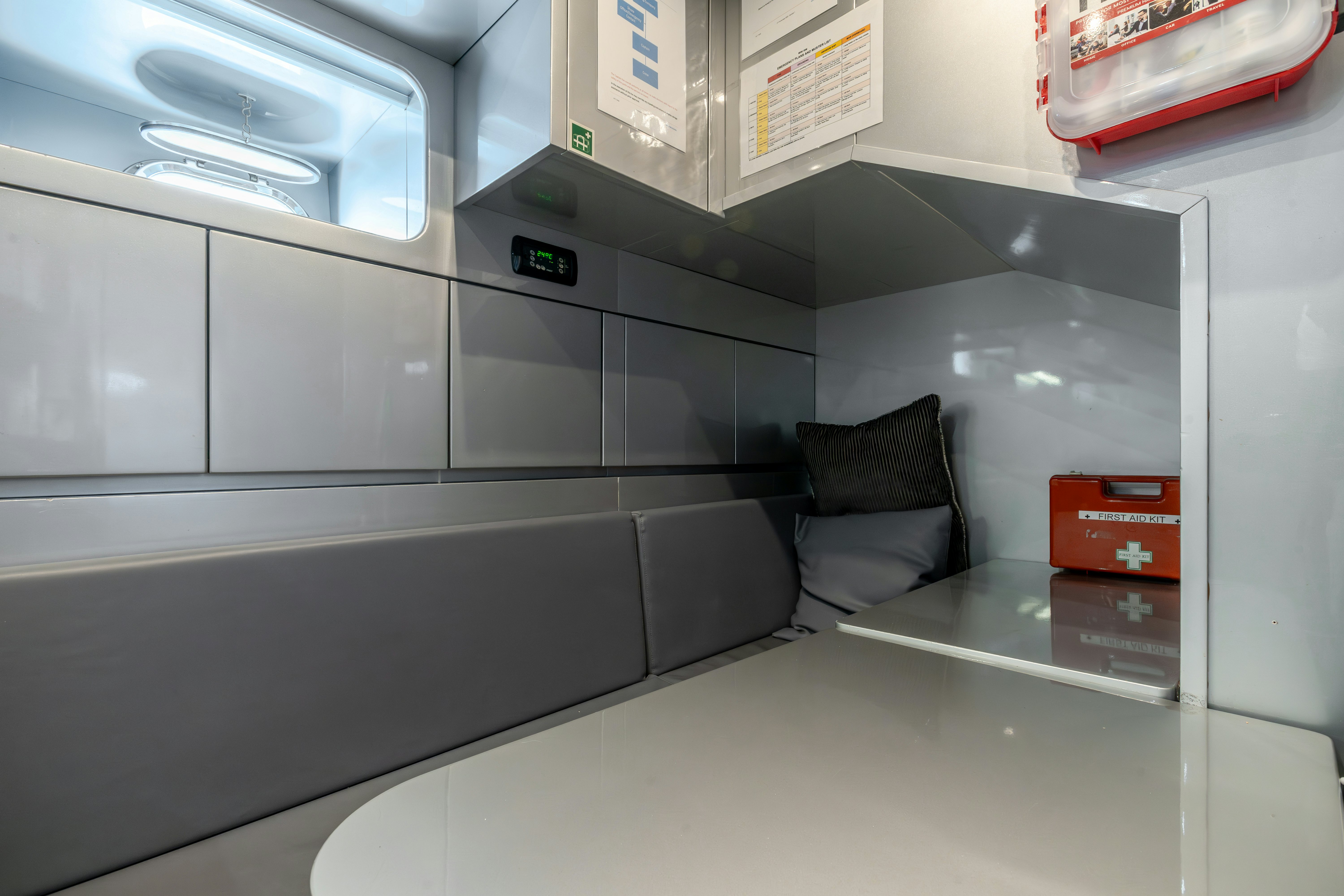 a room with a couch and a shelf with a box on it aboard TOTAL Yacht for Sale