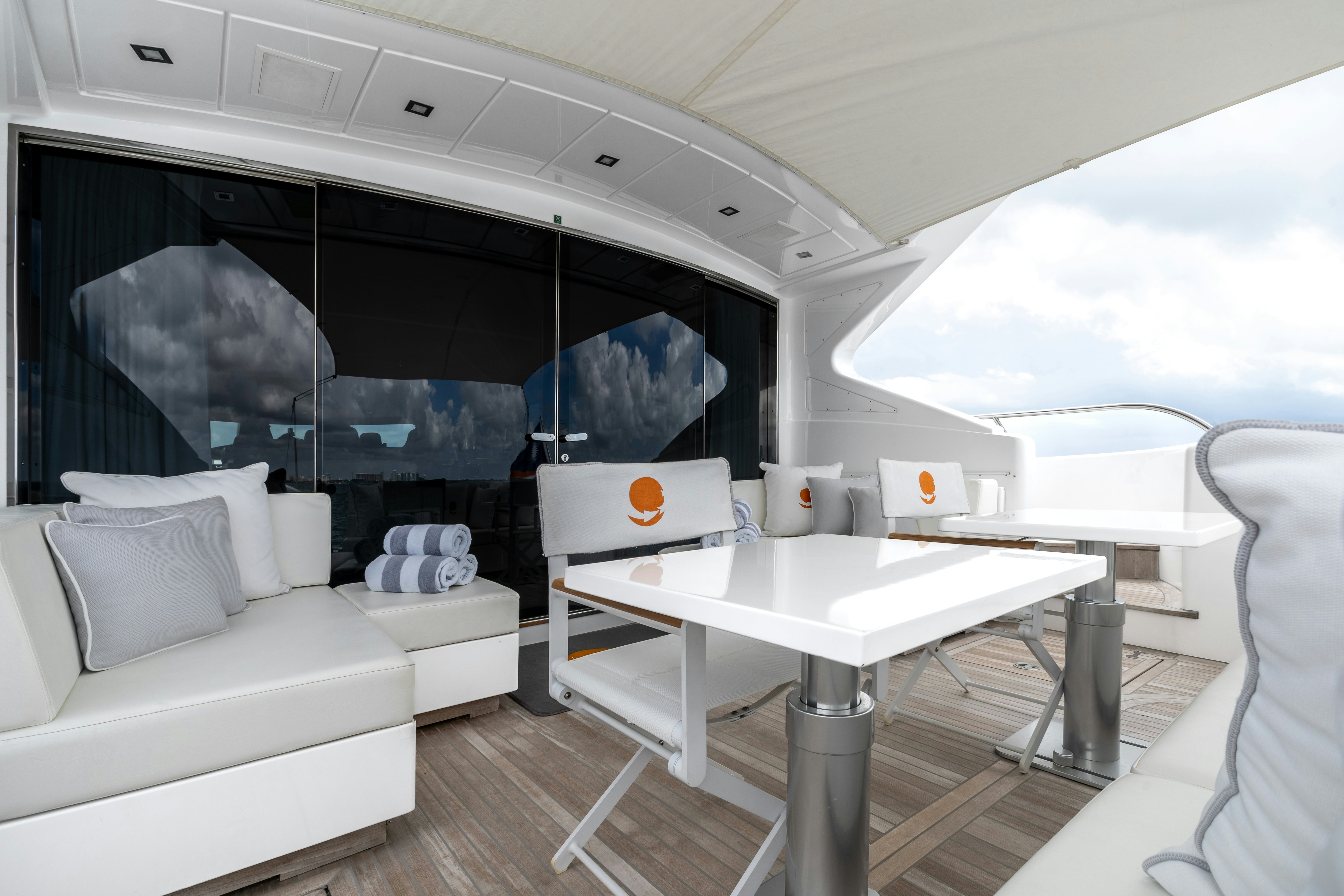 a room with a table and couches aboard TOTAL Yacht for Sale