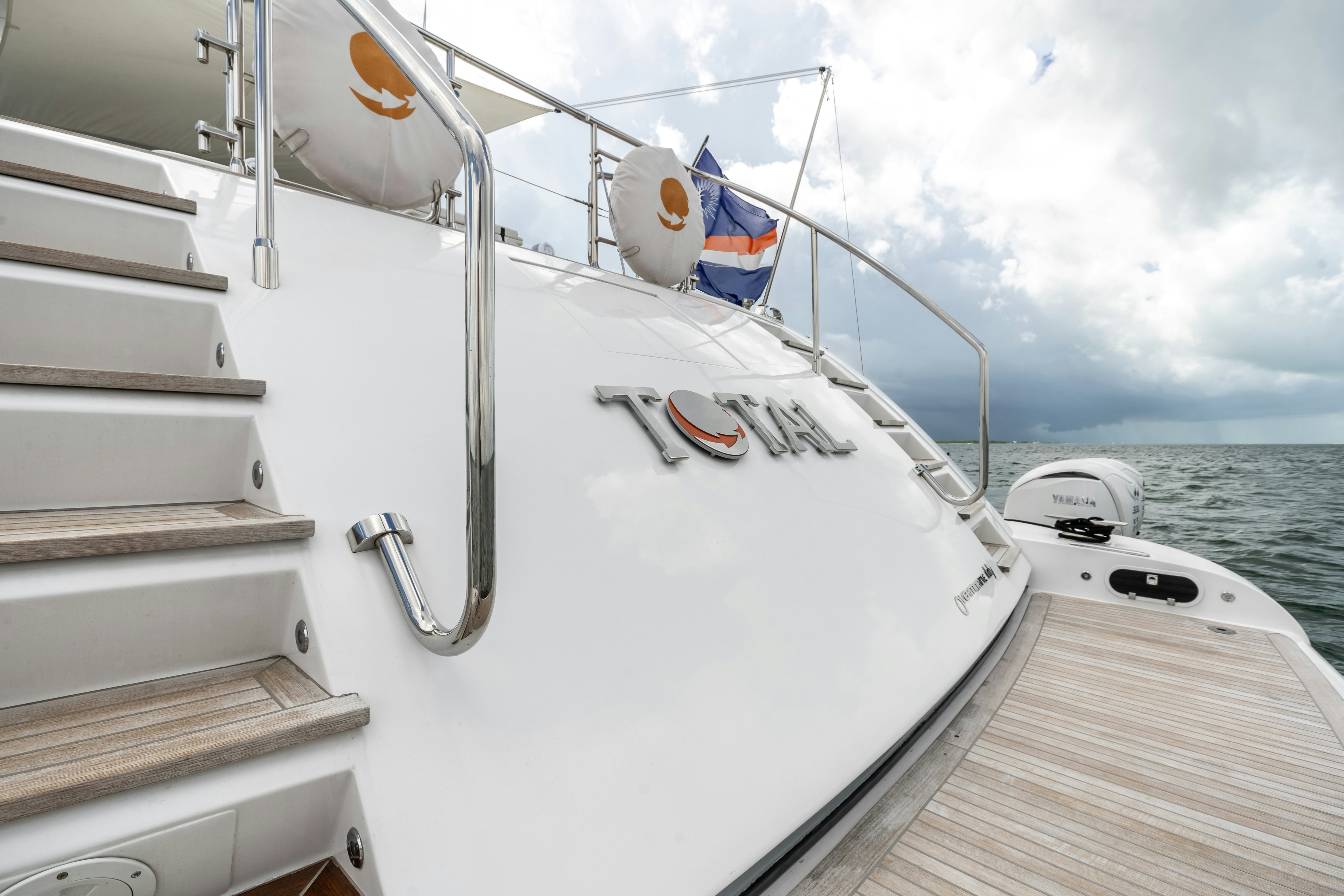 a boat with flags on the front aboard TOTAL Yacht for Sale