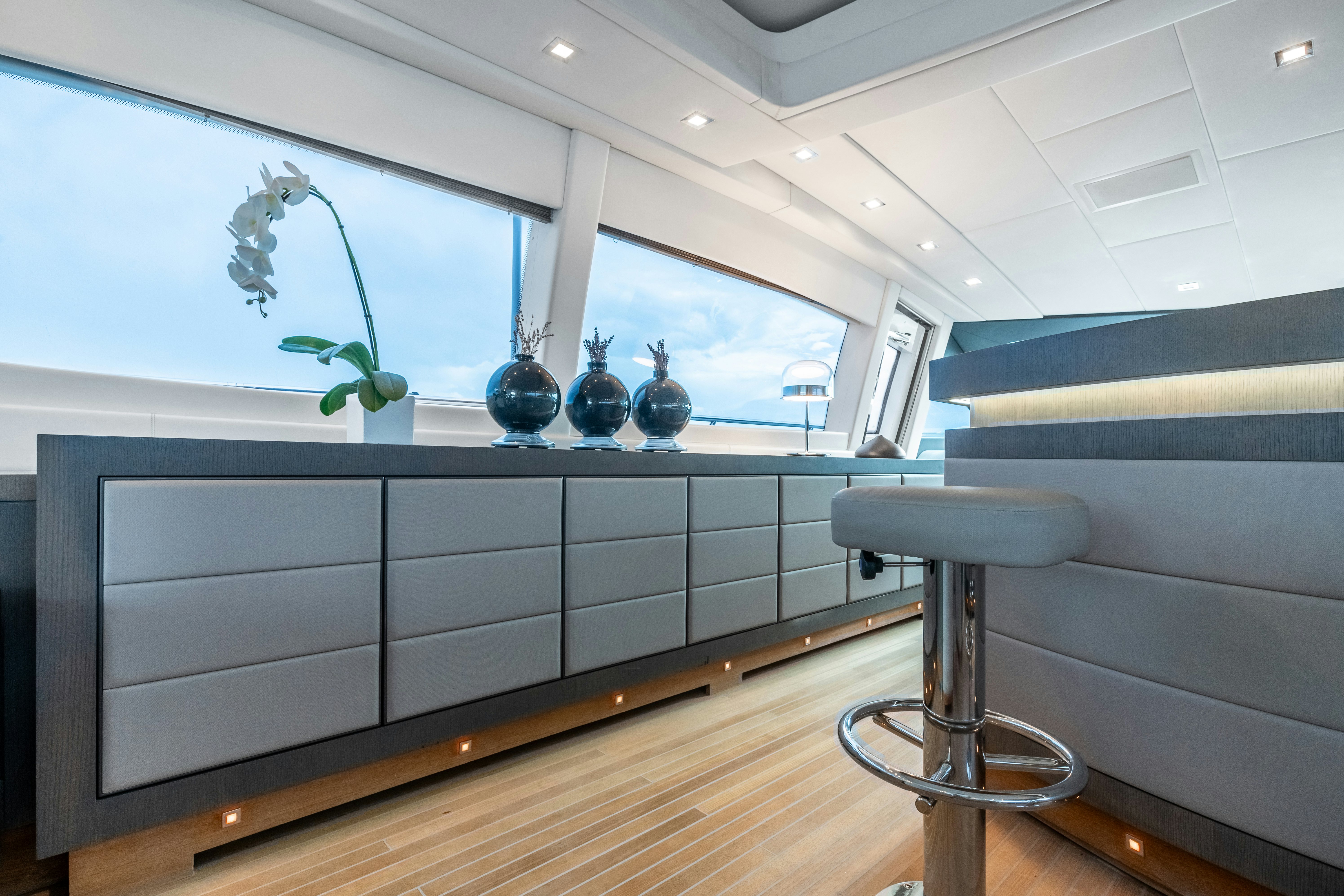a room with a table and stools aboard TOTAL Yacht for Sale