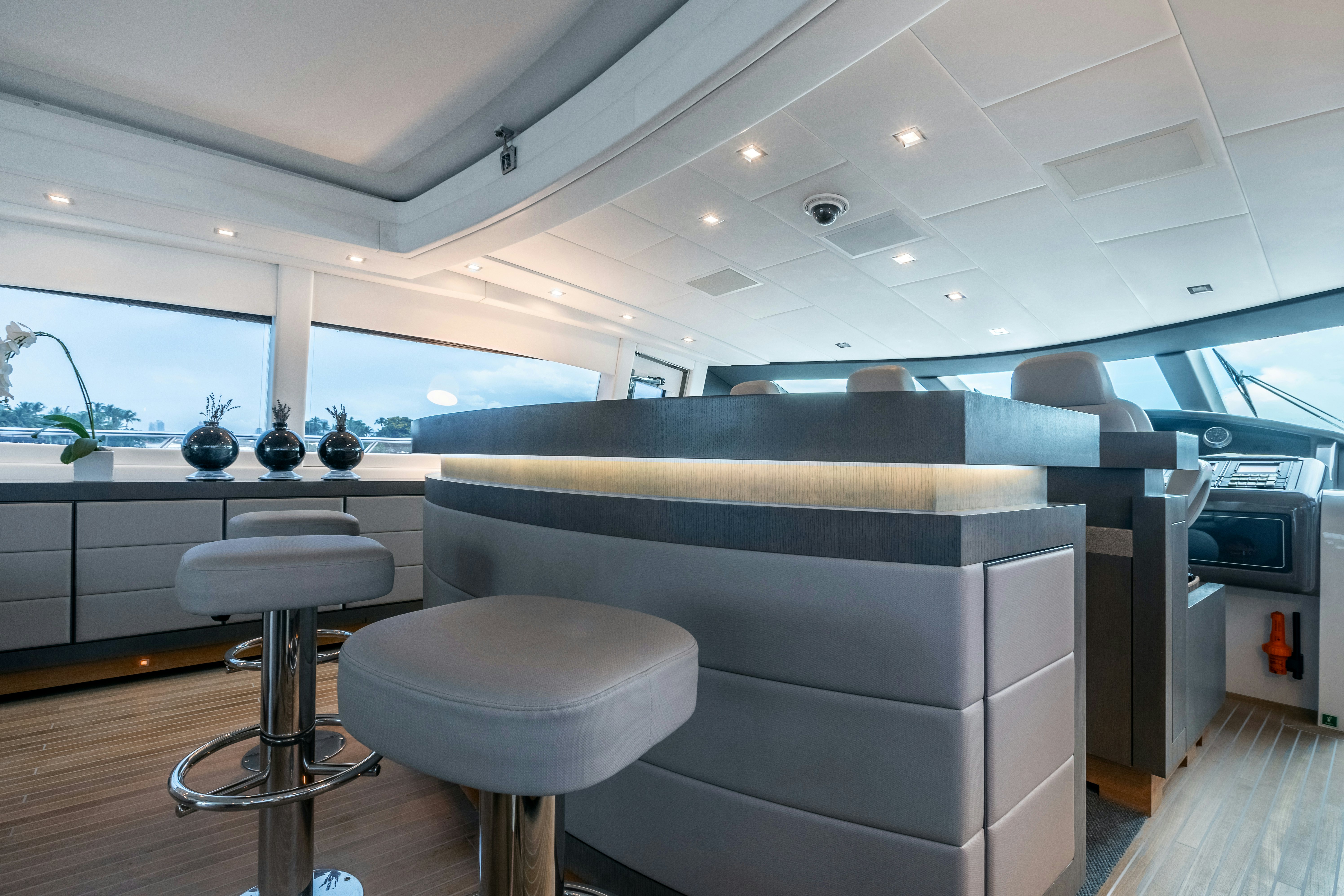 a room with a couch and stools aboard TOTAL Yacht for Sale