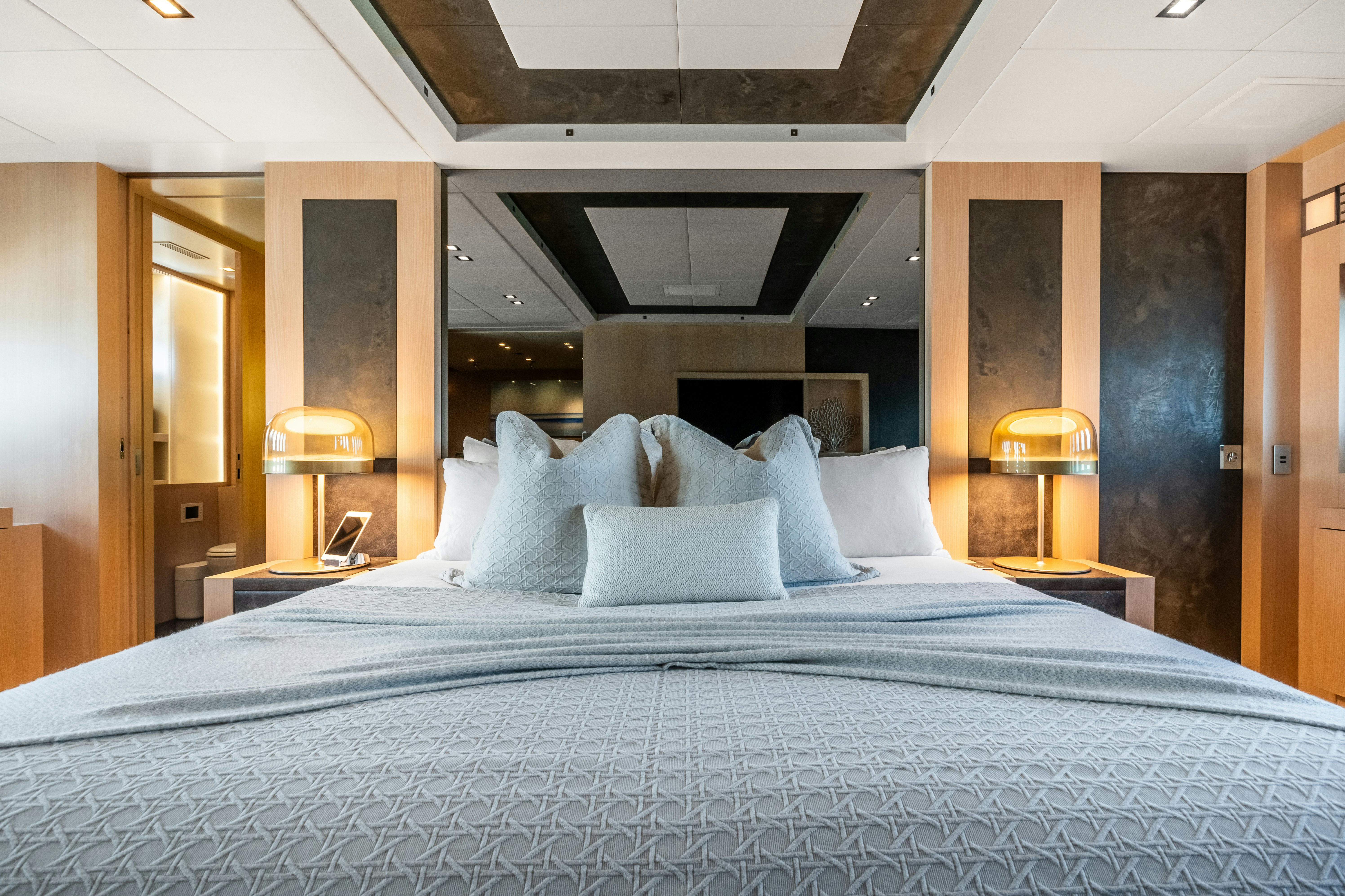 a bed with a blue comforter aboard TOTAL Yacht for Sale