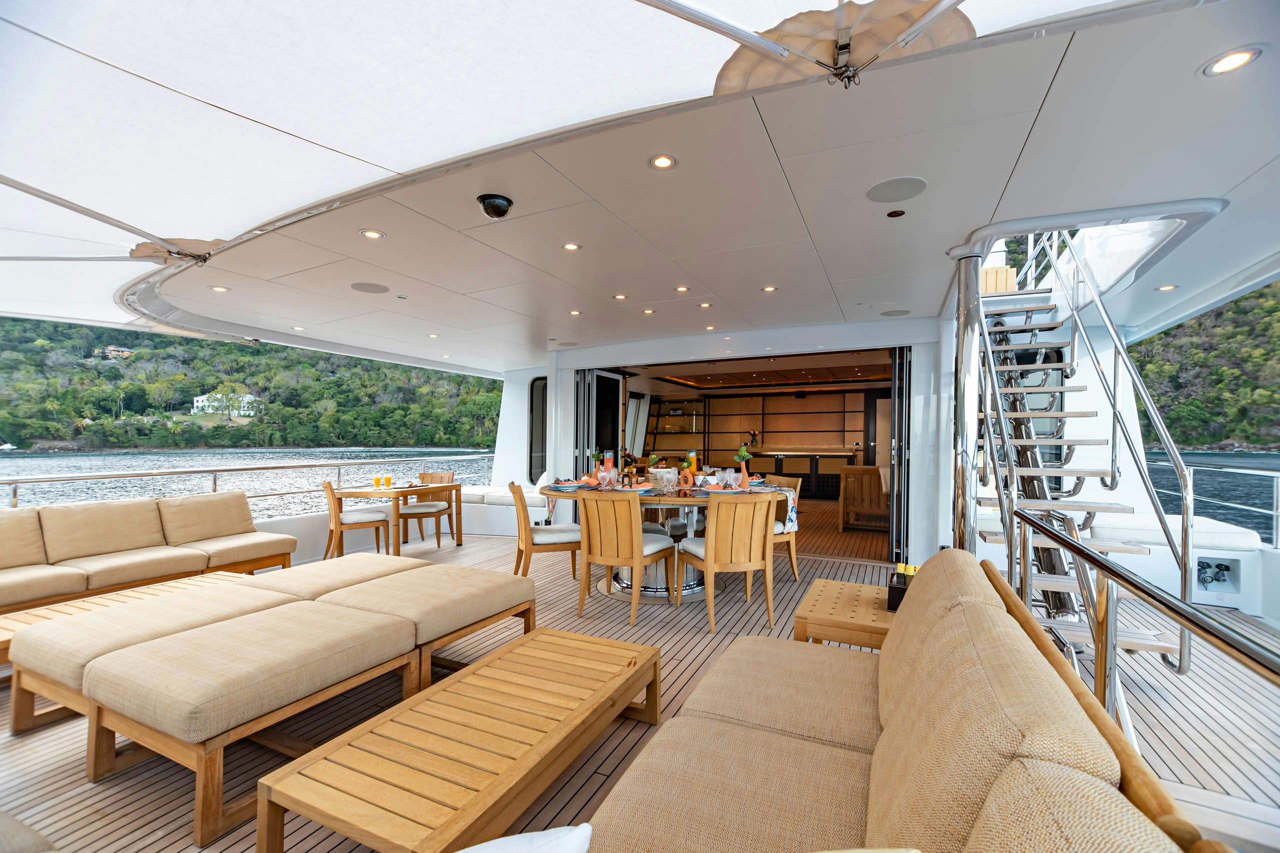 a living room with a staircase and a glass door leading to a balcony aboard HARLE Yacht for Charter