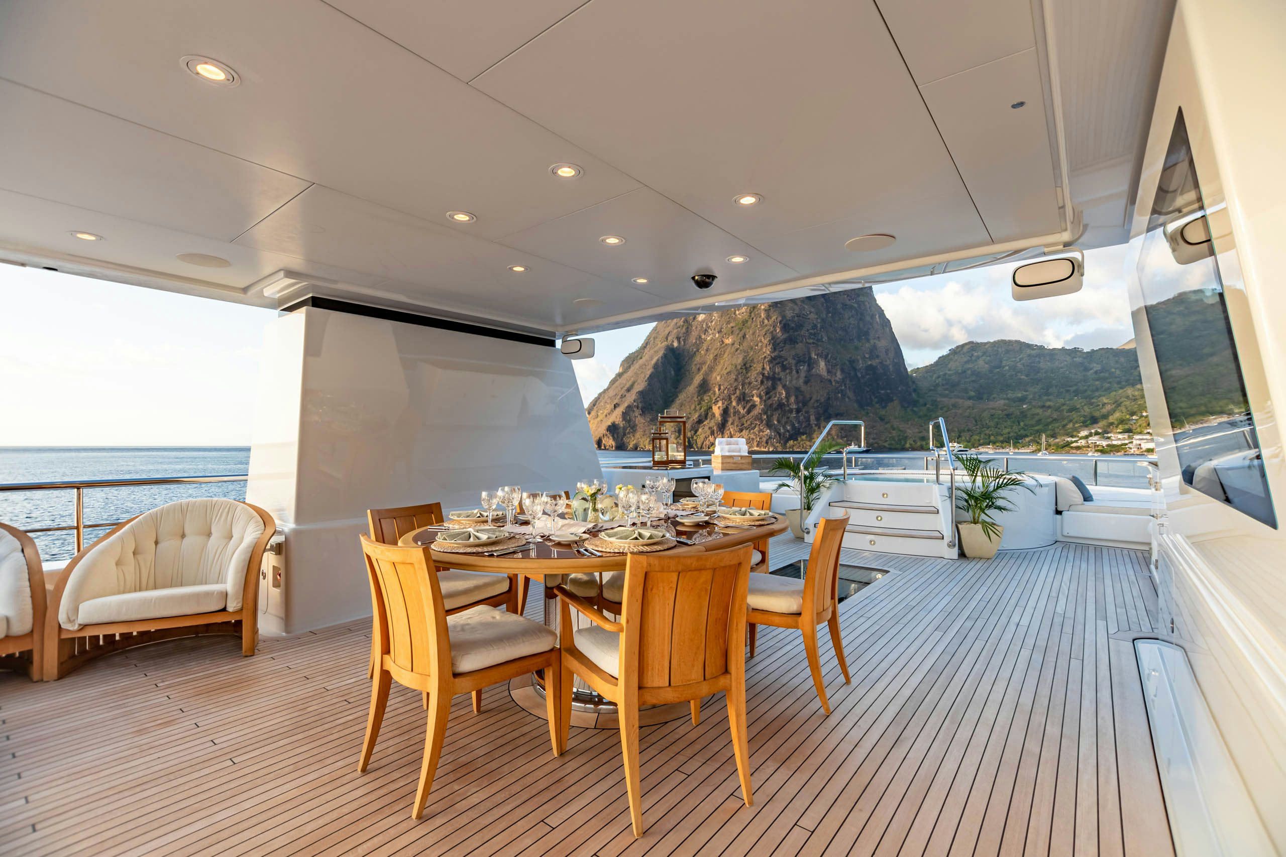 a dining table and chairs on a deck overlooking a large body of water aboard HARLE Yacht for Charter