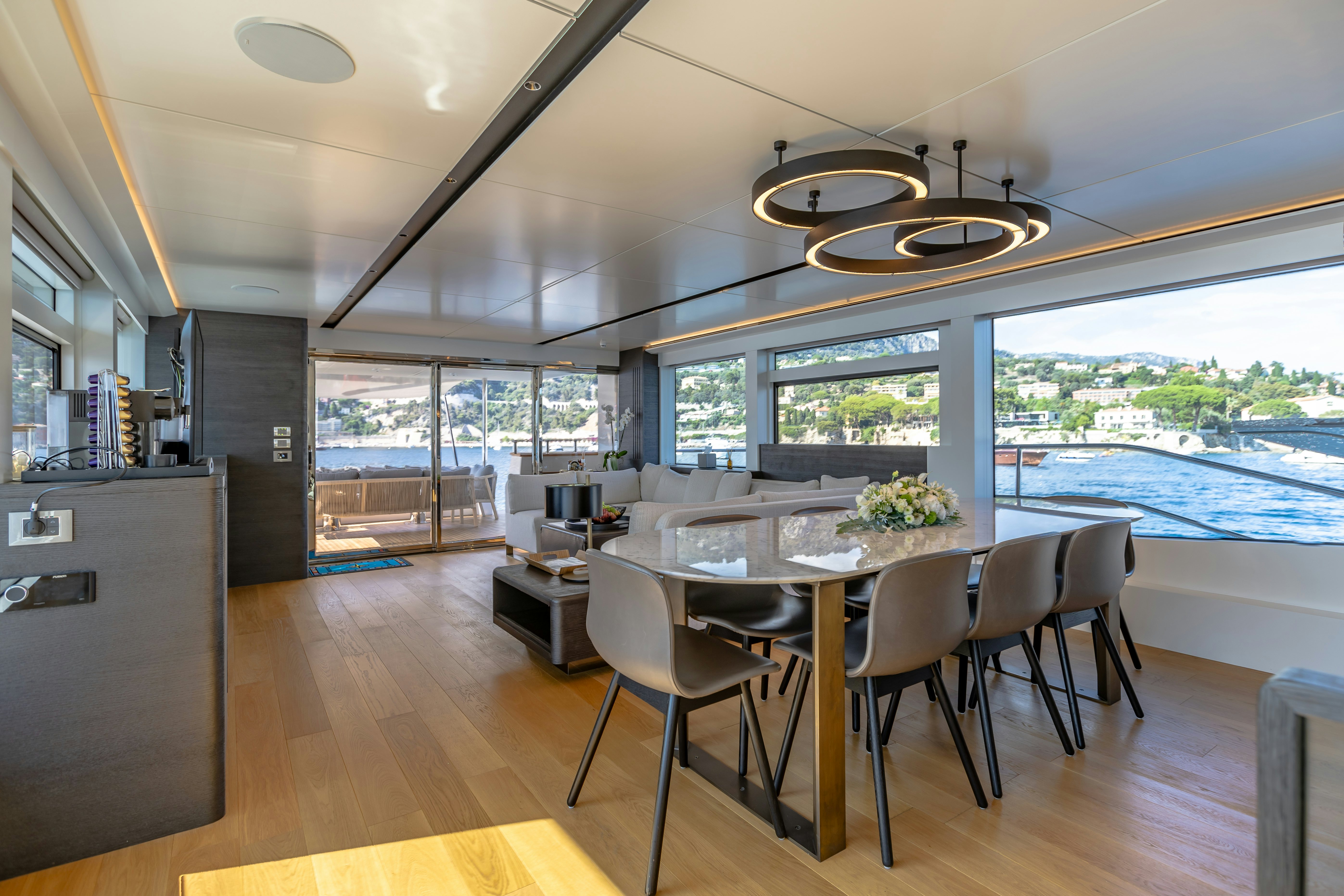 a large kitchen with a large dining table and a large window overlooking the ocean aboard MAORIA Yacht for Sale