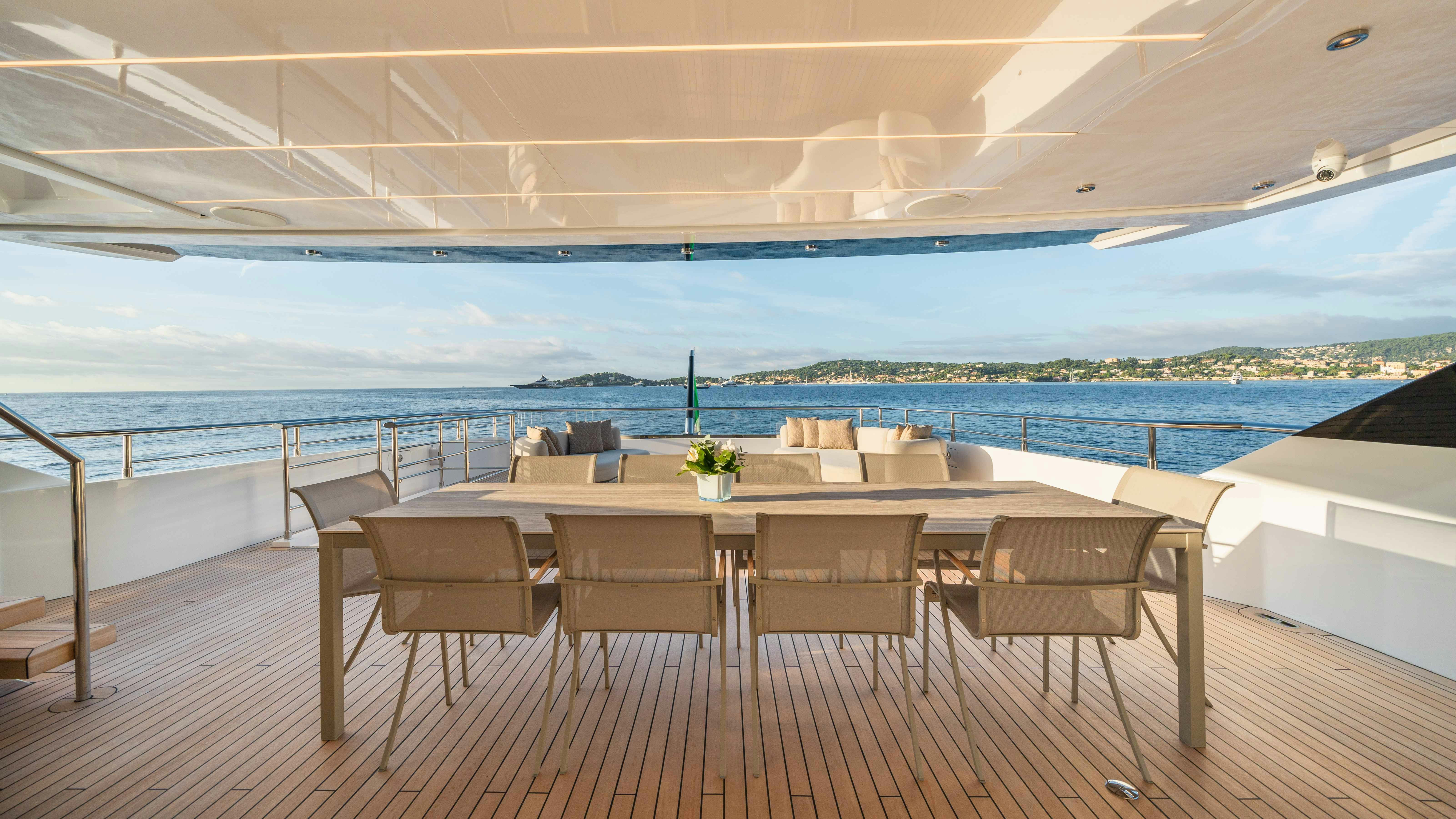 a table and chairs on a deck overlooking a body of water aboard OCEAN KING DUCALE 120 Yacht for Sale