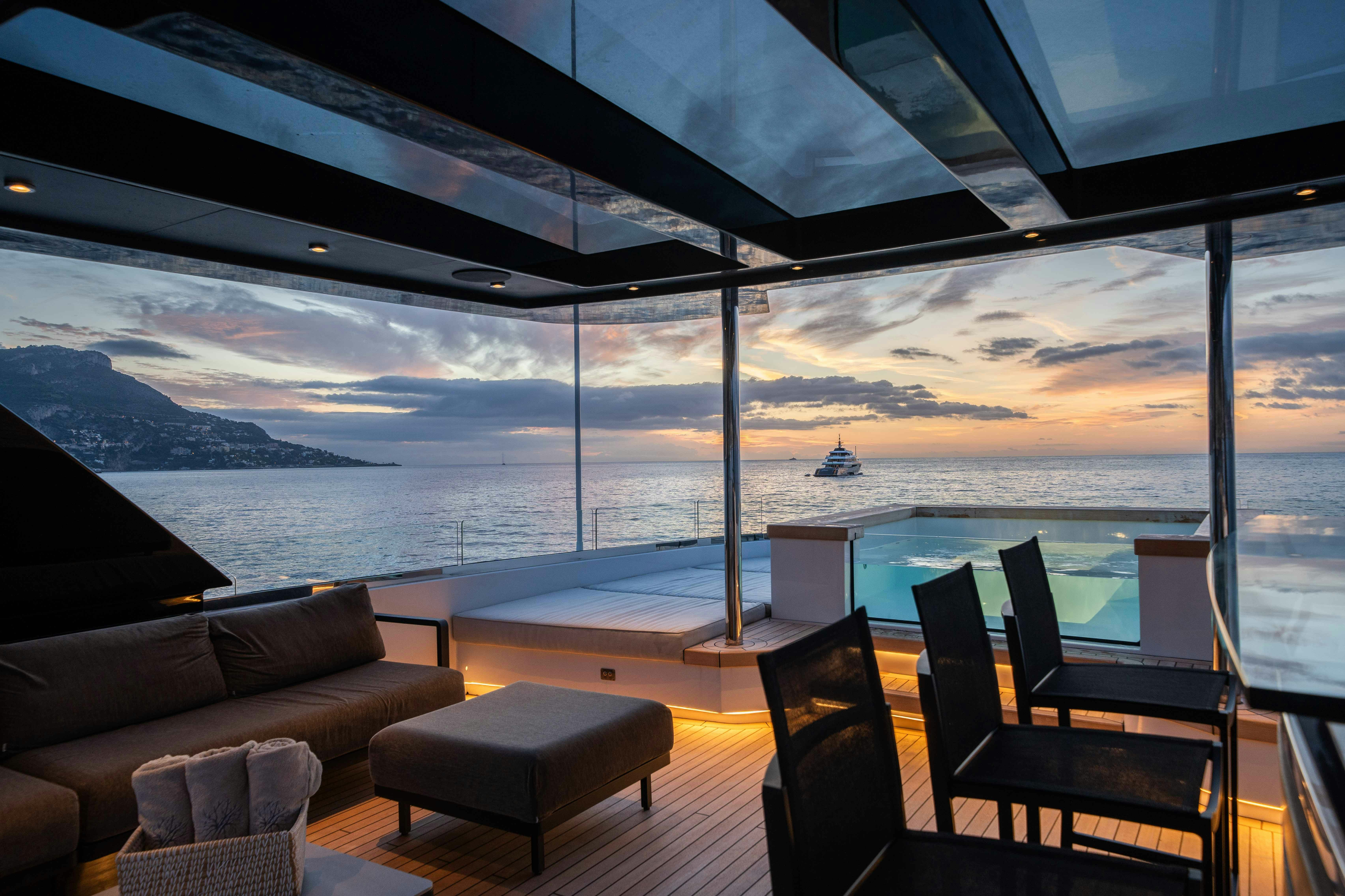 a deck with chairs and a boat in the water aboard OCEAN KING DUCALE 120 Yacht for Sale