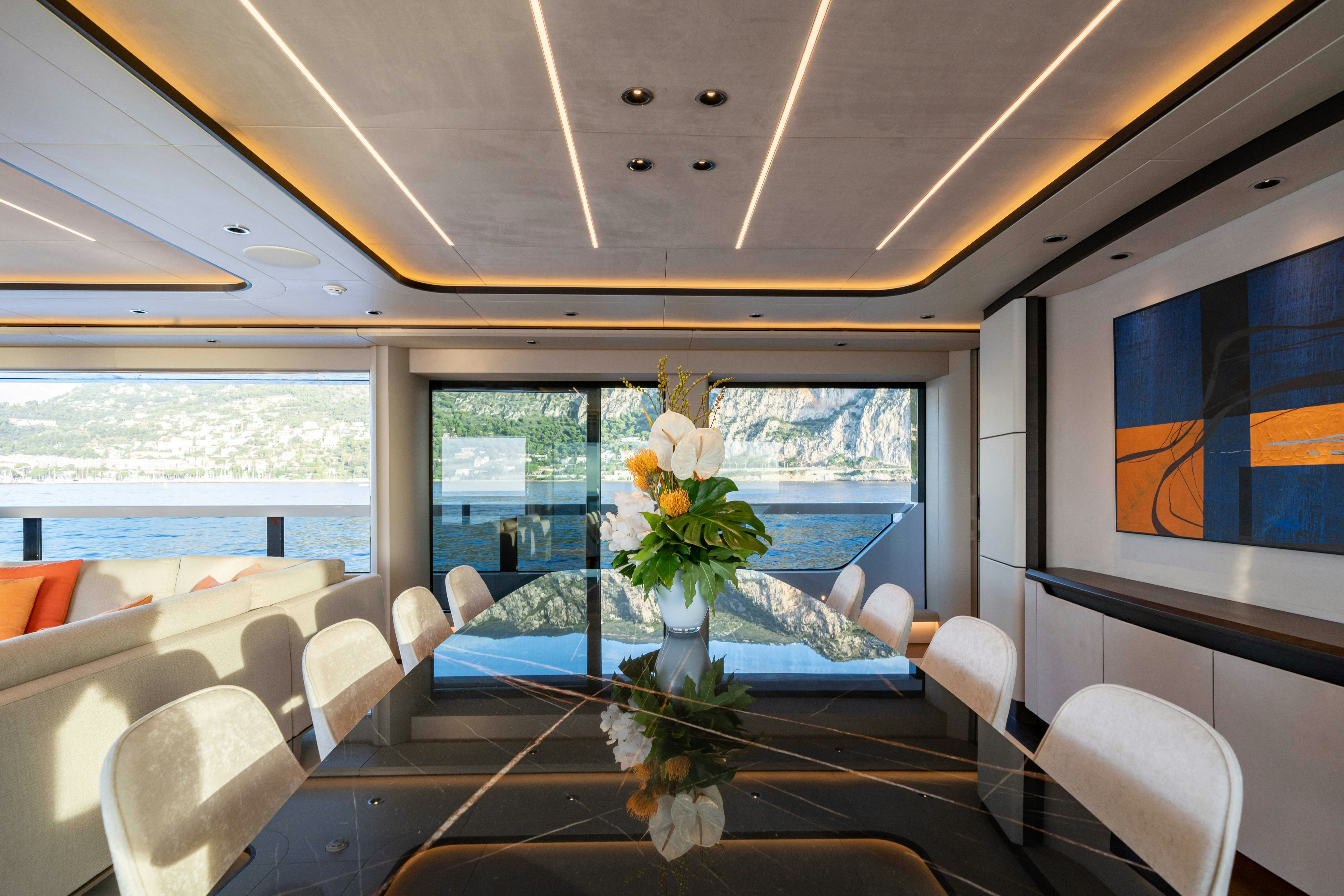 a room with a table and chairs aboard OCEAN KING DUCALE 120 Yacht for Sale