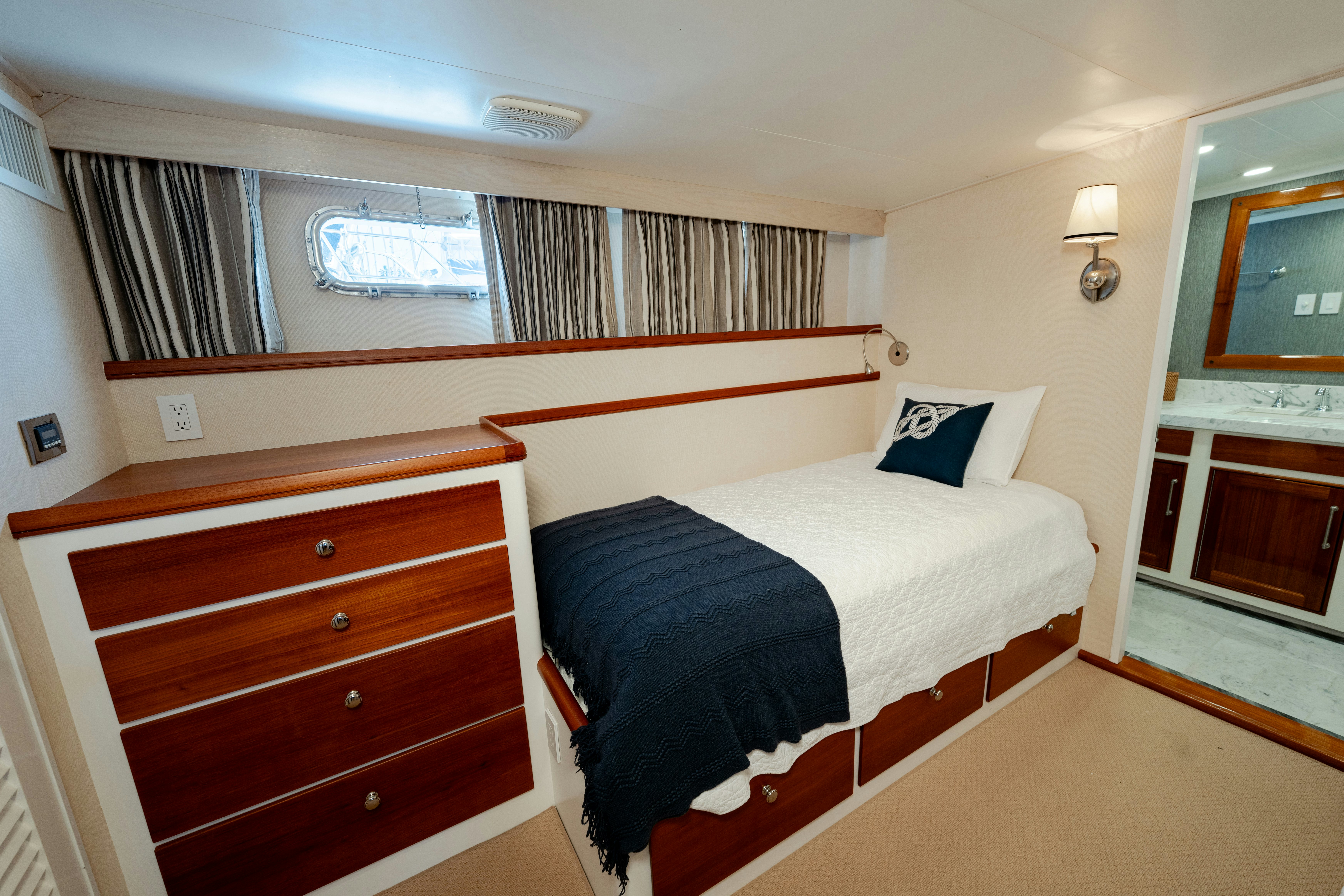 a bedroom with a bed and a dresser aboard NORDIC STAR Yacht for Sale