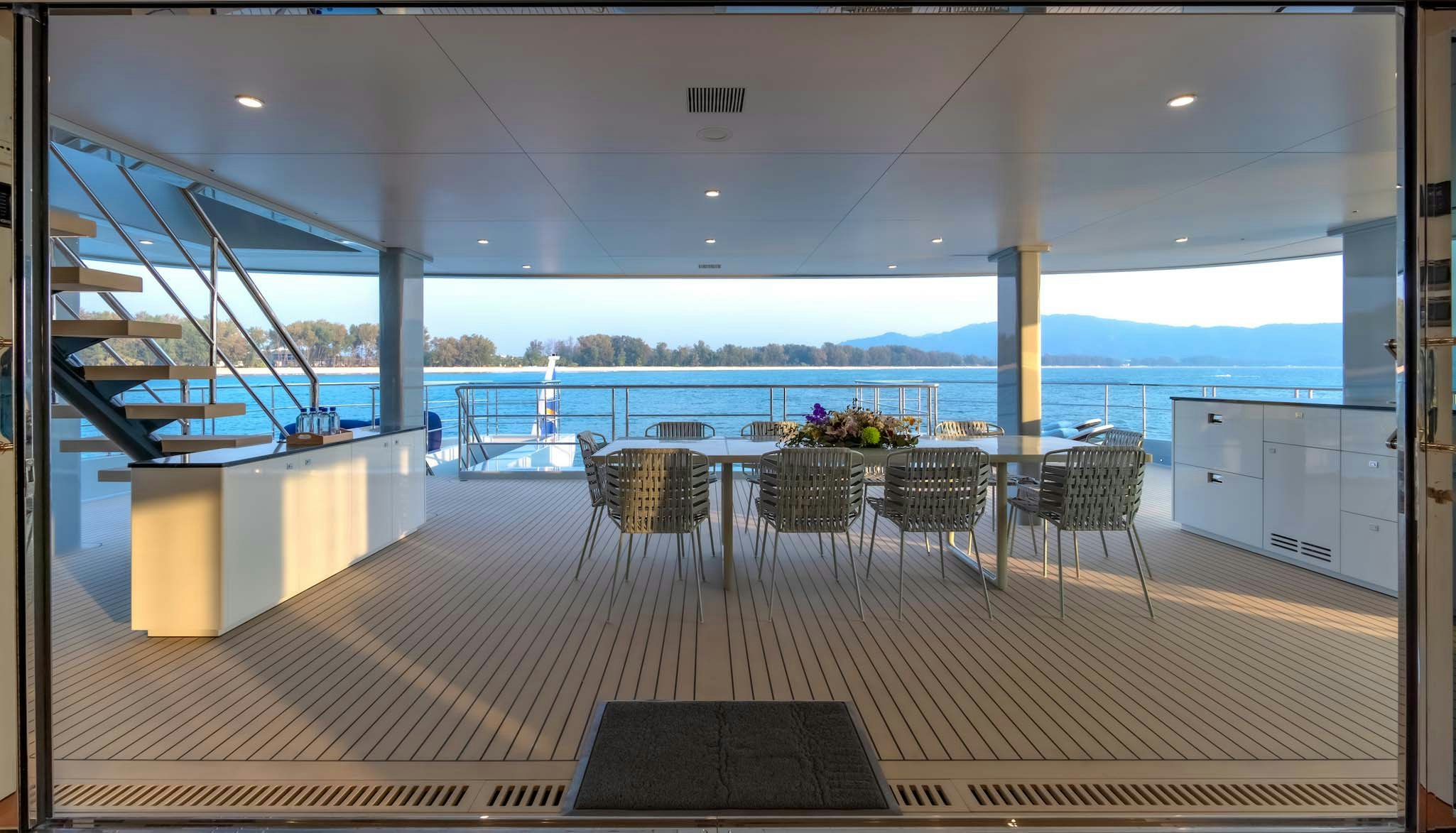a deck with a table and chairs aboard SPACECAT Yacht for Charter