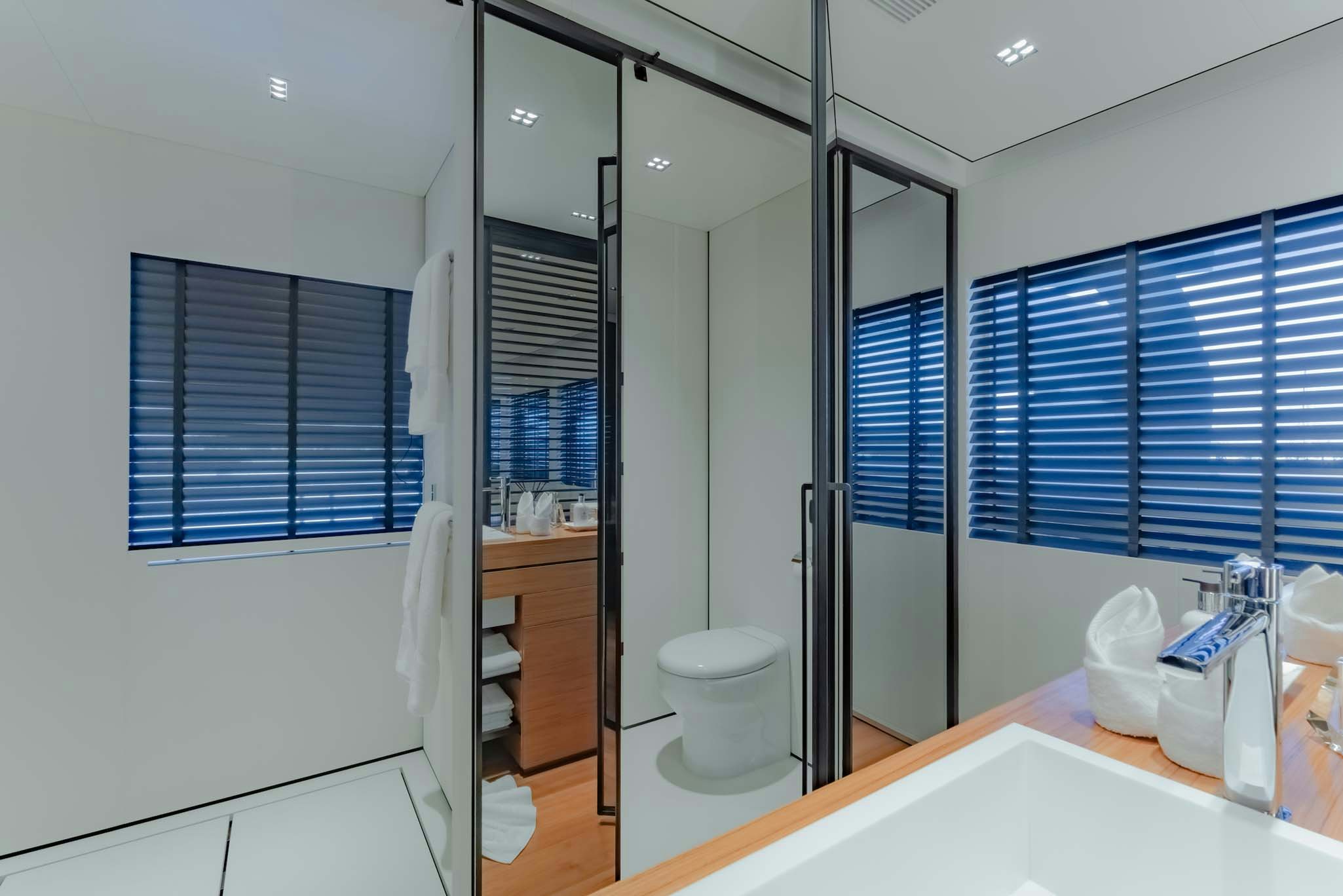 a bathroom with a glass shower aboard SPACECAT Yacht for Charter