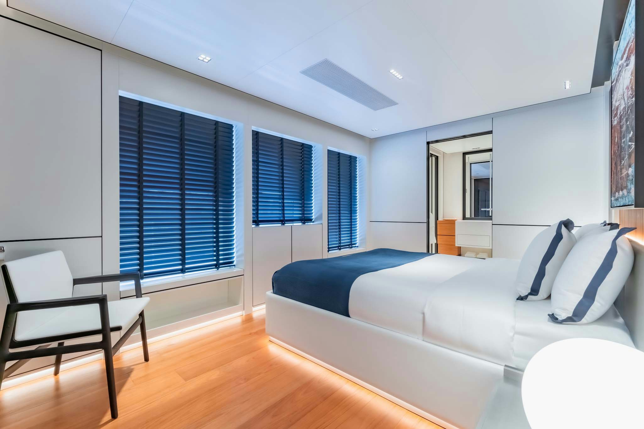 a bedroom with a bed and a chair aboard SPACECAT Yacht for Charter