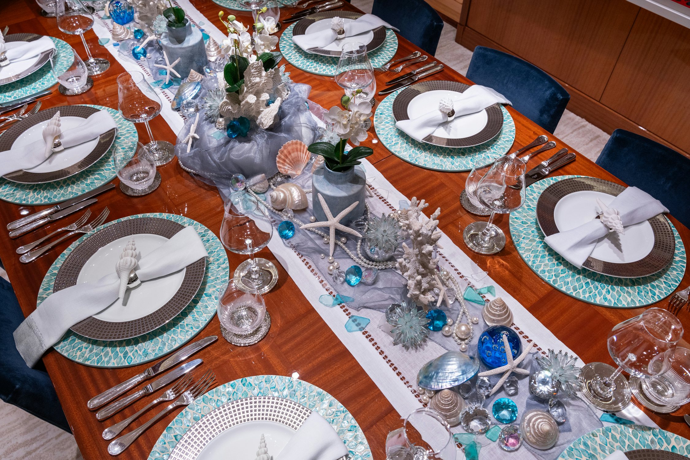 a table with plates and silverware aboard AMICA MEA Yacht for Charter