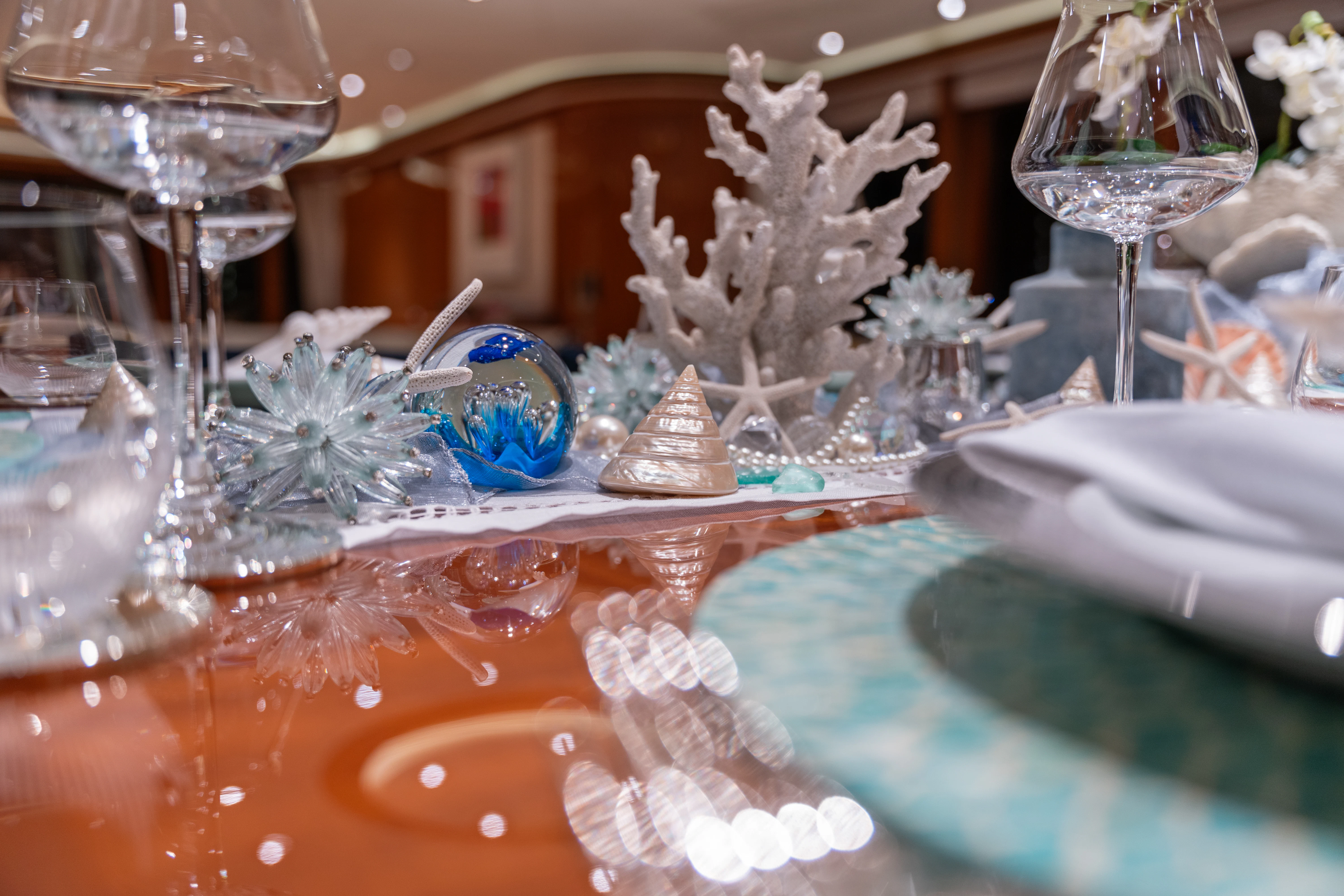 a glass table with a glass ball and a decorated tree aboard AMICA MEA Yacht for Sale
