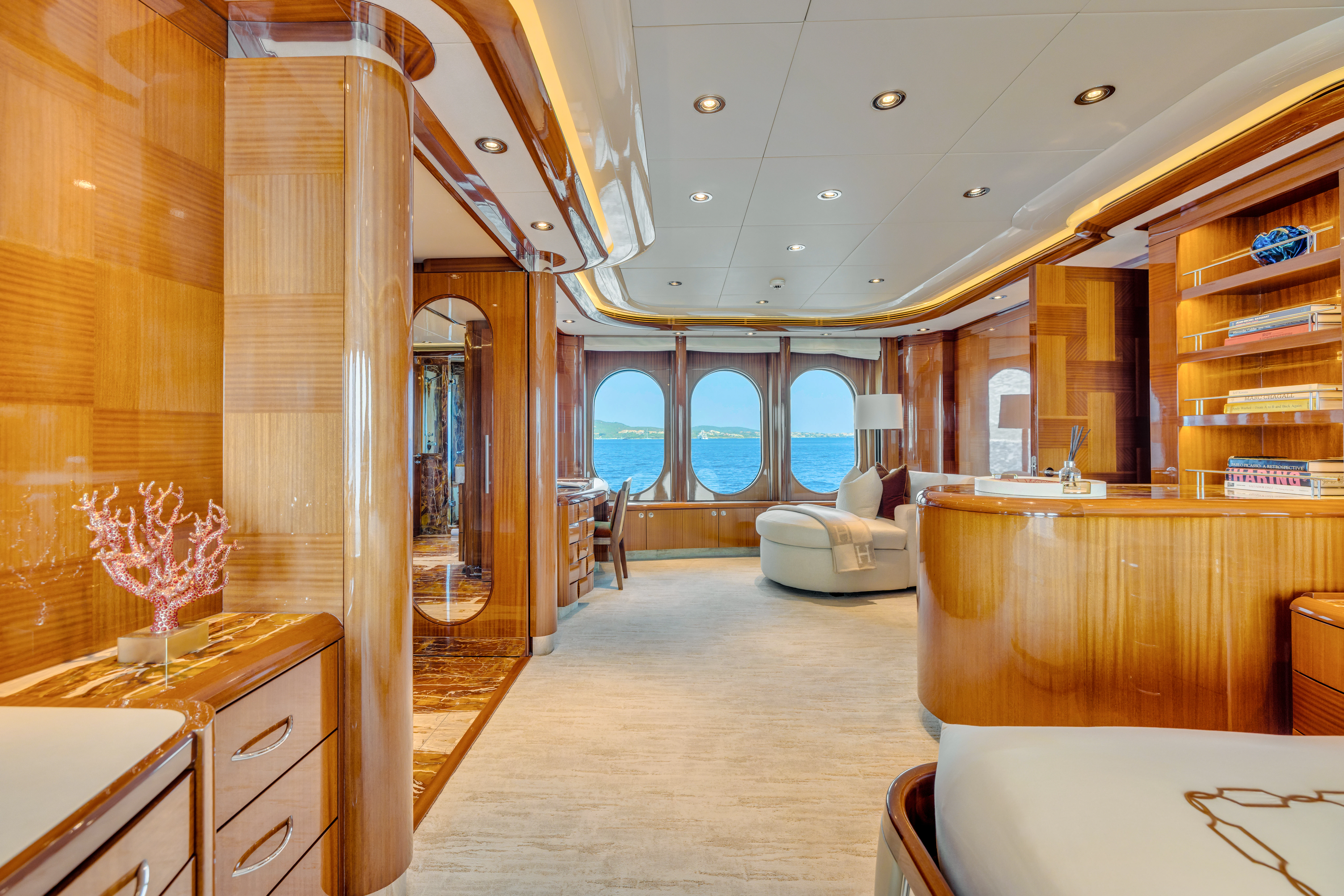 a room with wood walls and a white couch and a large window aboard AMICA MEA Yacht for Sale