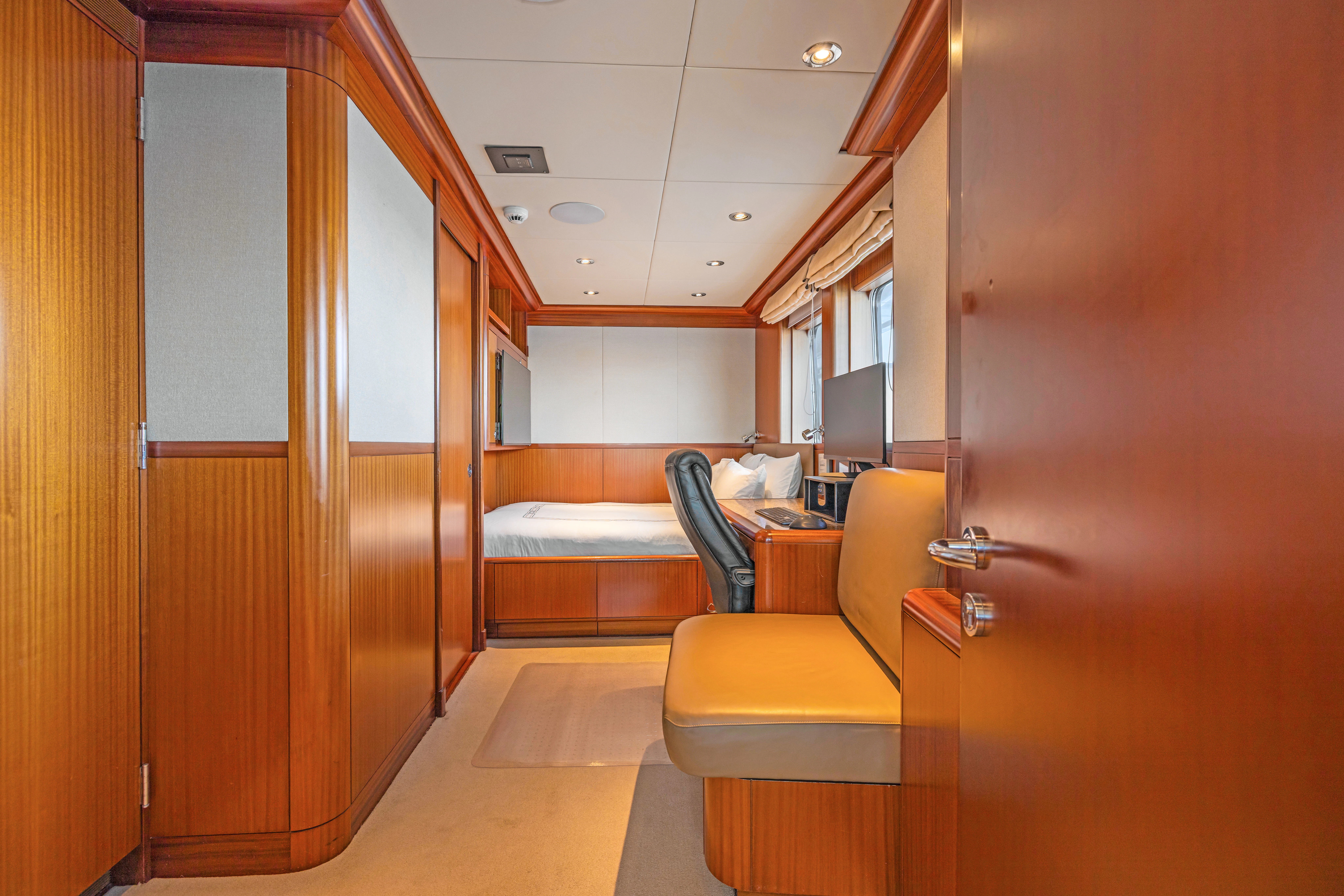a room with a bed and desk aboard AMICA MEA Yacht for Sale
