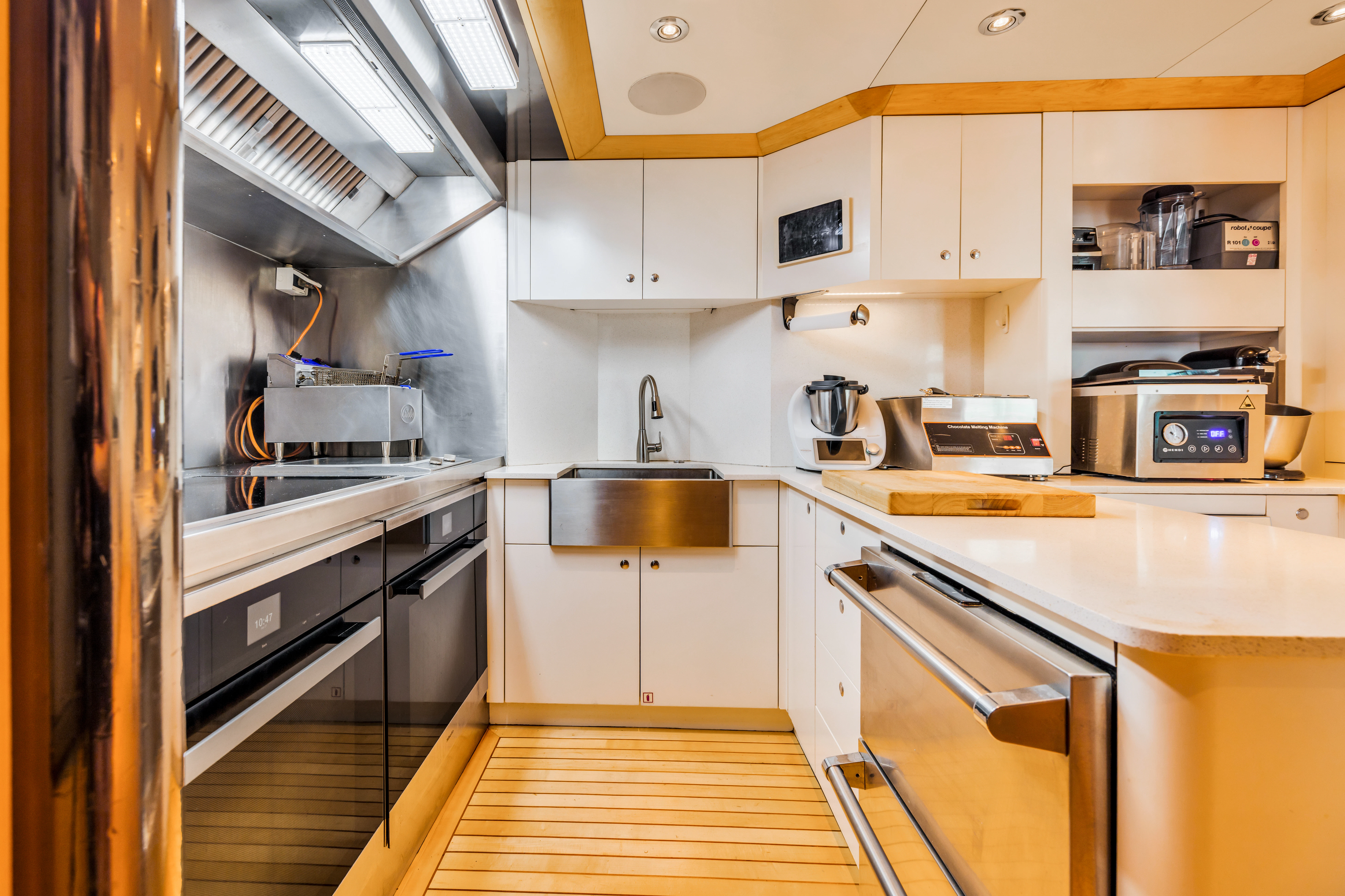 a kitchen with white cabinets aboard AMICA MEA Yacht for Sale