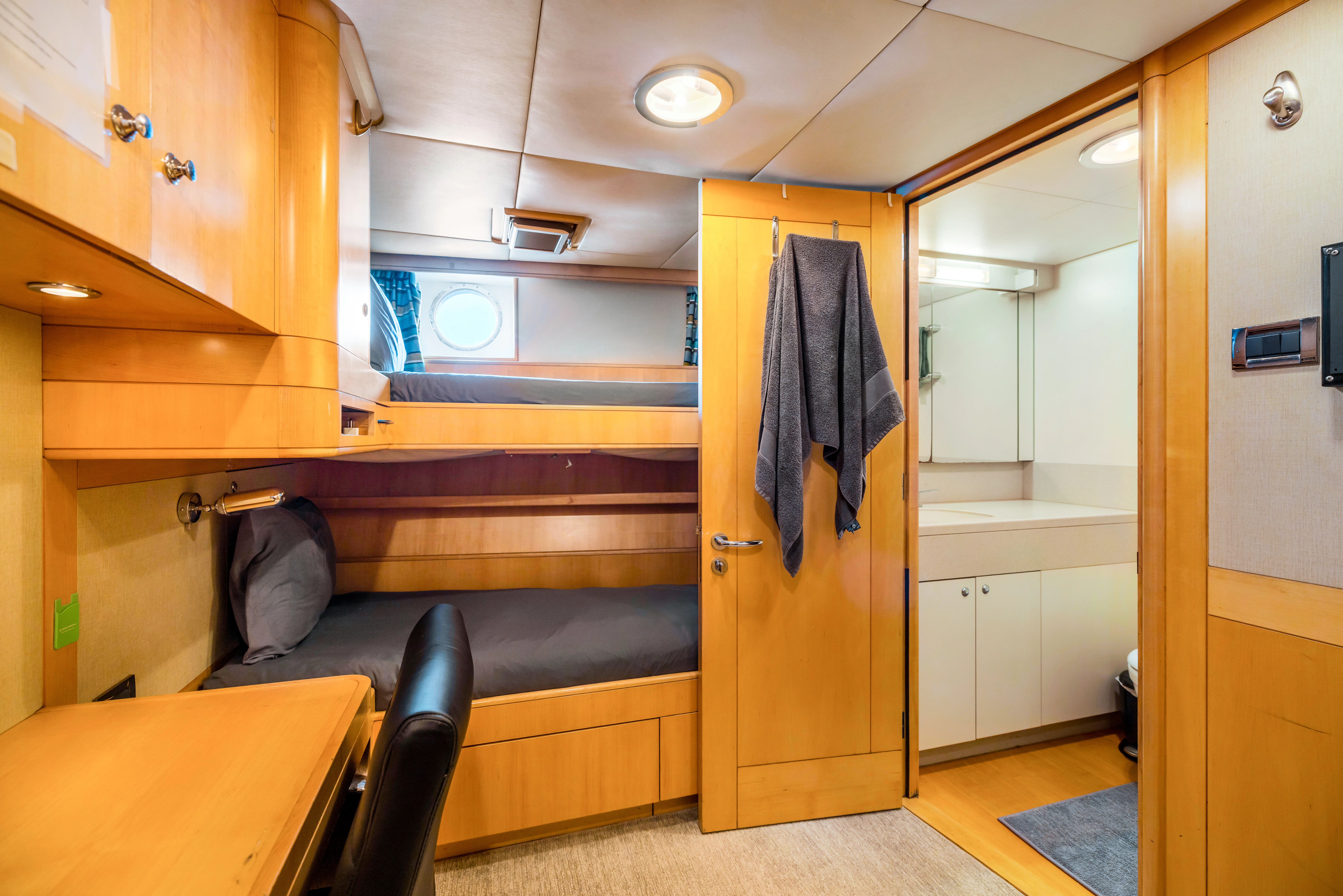 a room with a bed and desk aboard AMICA MEA Yacht for Sale