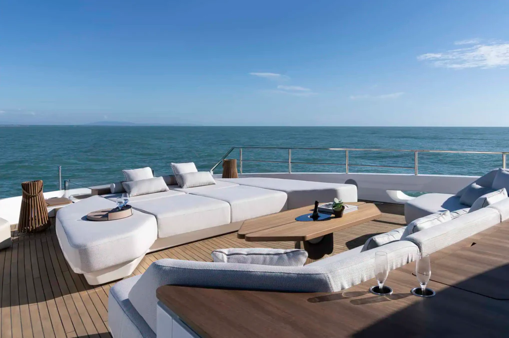 a room with a bed and a table and chairs on a deck aboard ILMA Yacht for Charter