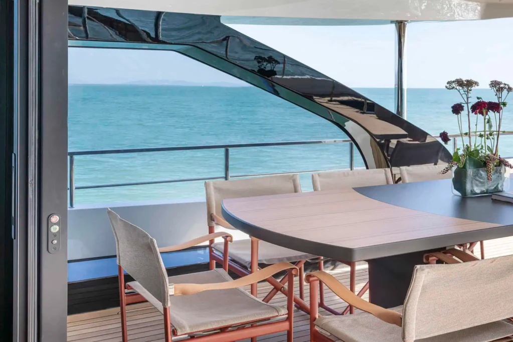 a table and chairs on a balcony aboard ILMA Yacht for Charter