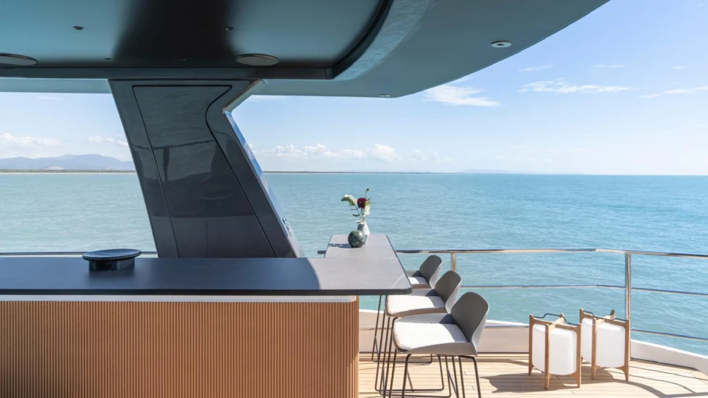 a room with a table and chairs on it by the ocean aboard ILMA Yacht for Charter