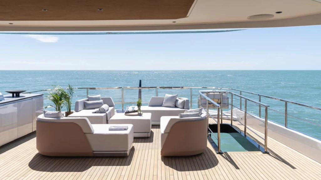 a room with a couch and a table and a view of the ocean aboard ILMA Yacht for Charter