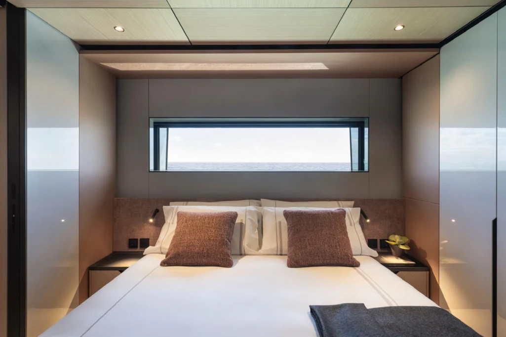 a bed with a white bed spread aboard ILMA Yacht for Charter