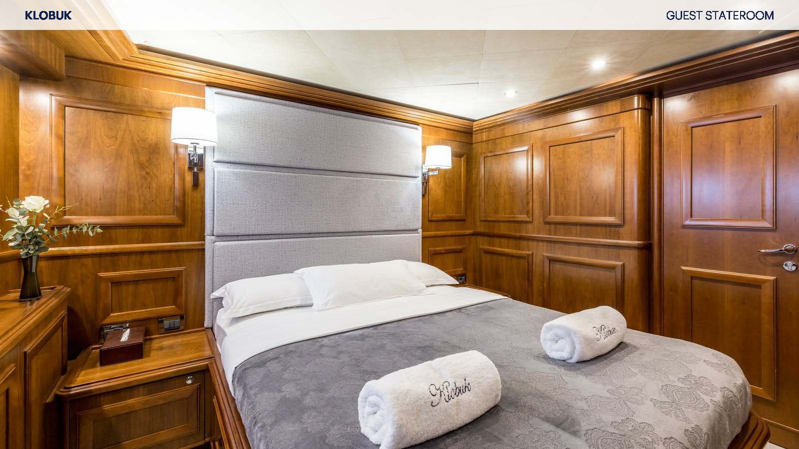 a bed with white sheets aboard KLOBUK Yacht for Charter