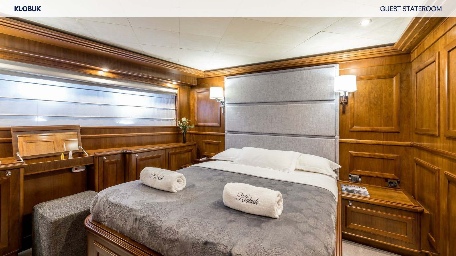a bedroom with a bed and a dresser aboard KLOBUK Yacht for Charter