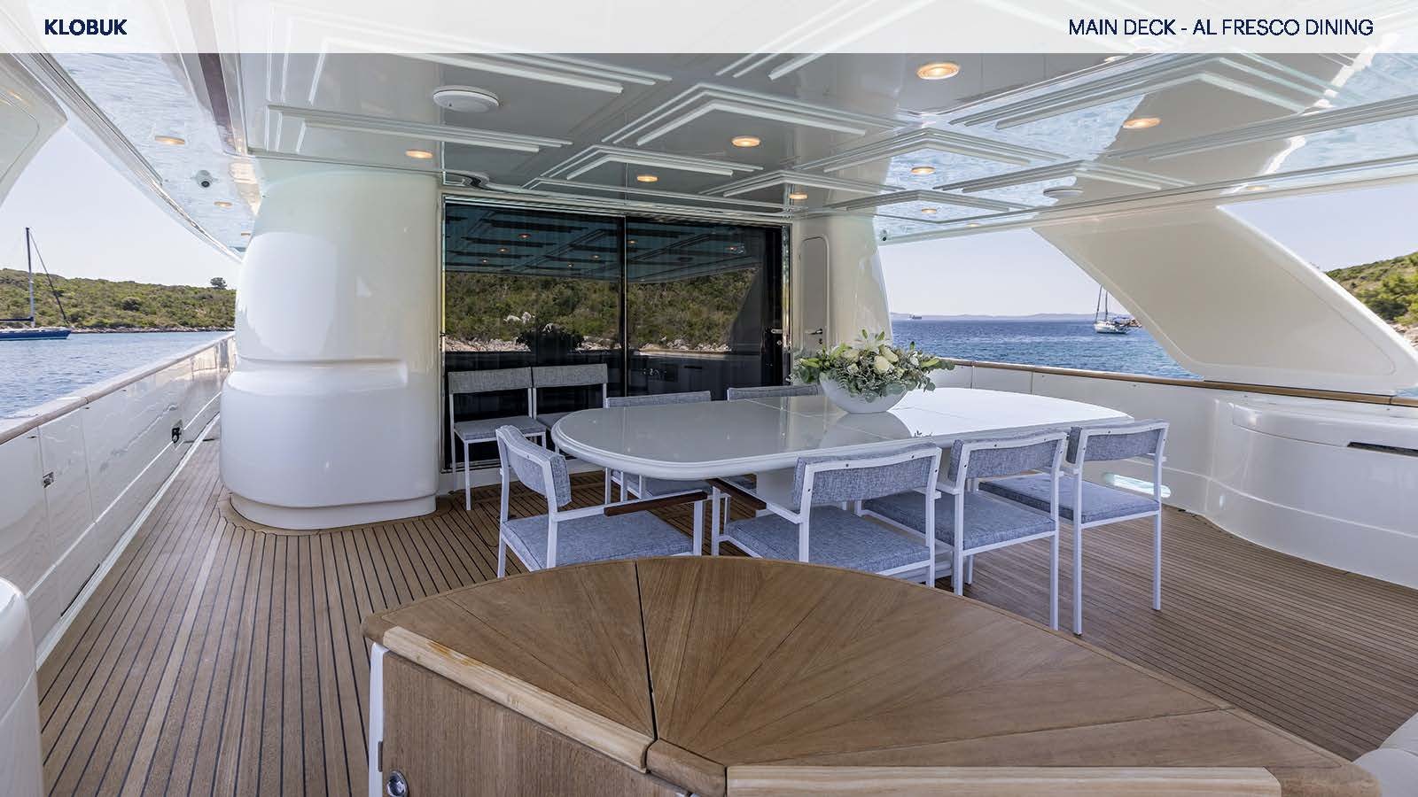 a deck with tables and chairs aboard KLOBUK Yacht for Charter