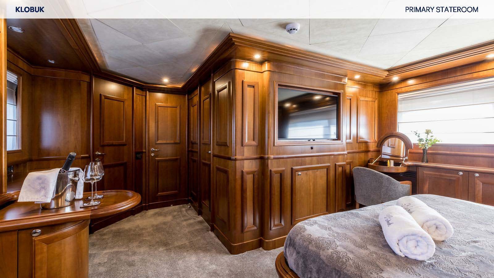 a bedroom with a bed and a glass door aboard KLOBUK Yacht for Charter