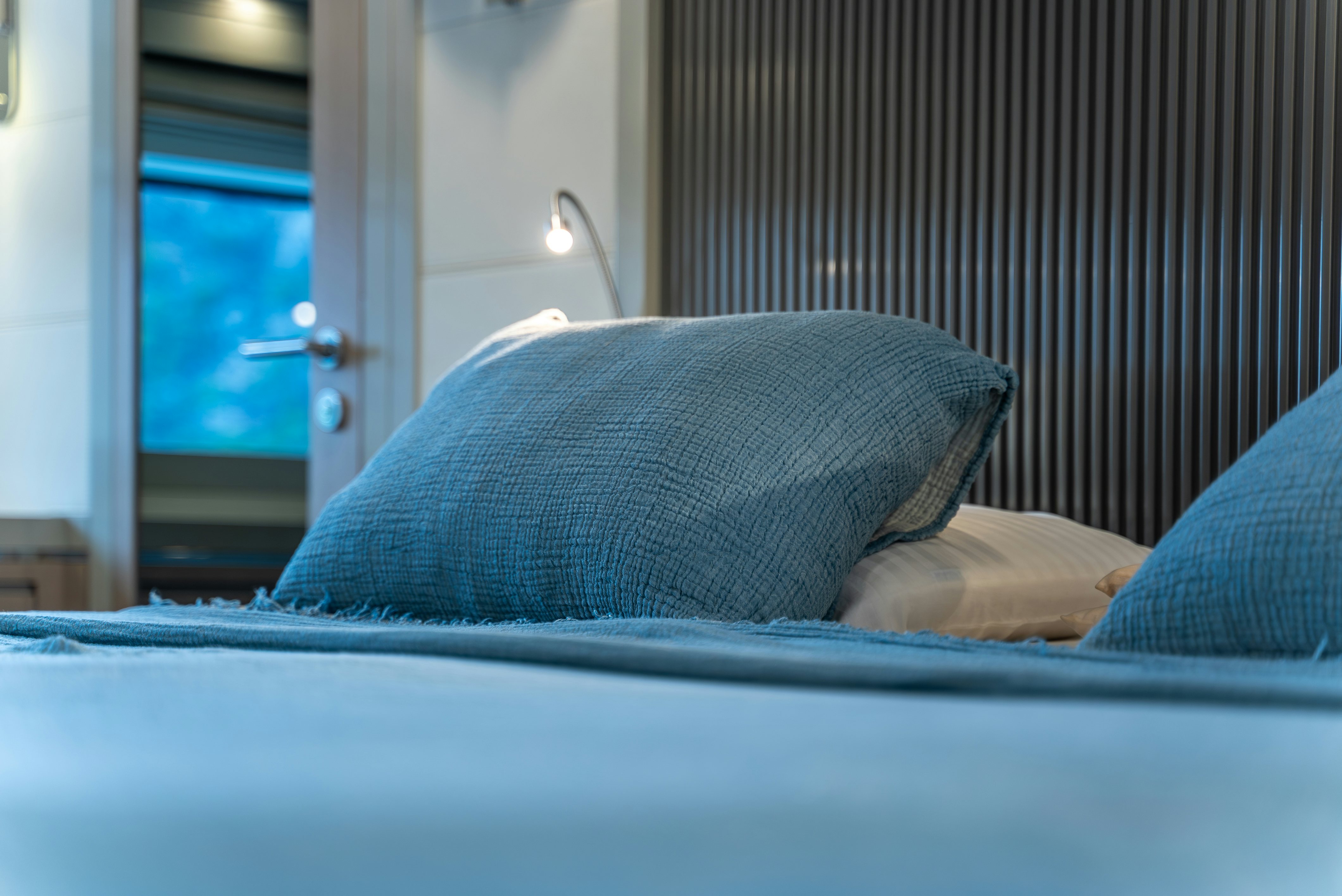 a bed with blue pillows aboard GALENE IV Yacht for Sale