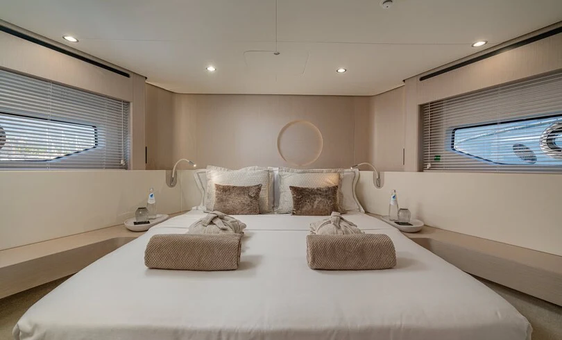 a large white bed with a white sheet and a round pillow on it aboard SBK Yacht for Charter
