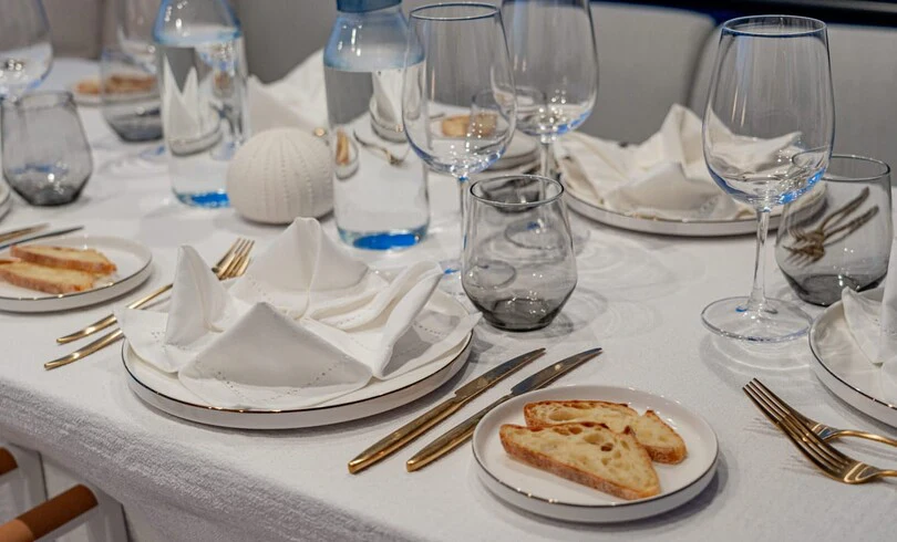 a table with plates and glasses aboard SBK Yacht for Charter