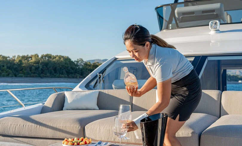 a person holding a glass of liquid aboard SBK Yacht for Charter