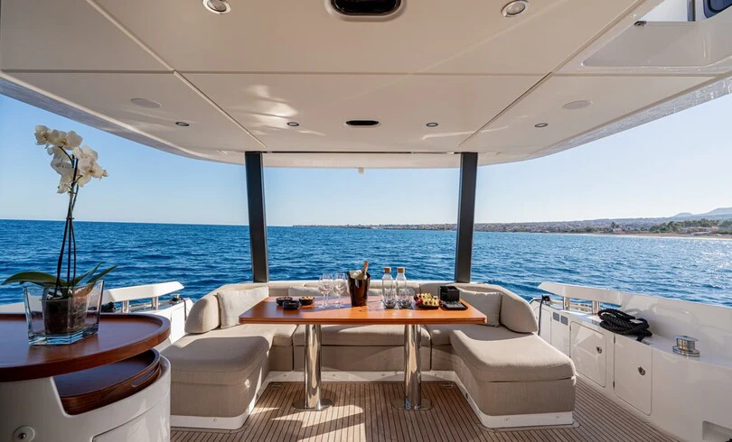 a room with a table chairs and a view of the ocean aboard SBK Yacht for Charter