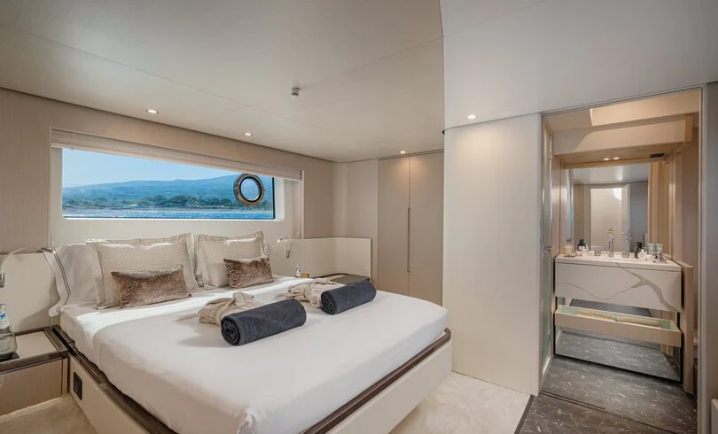 a bedroom with a bed and a mirror aboard SBK Yacht for Charter