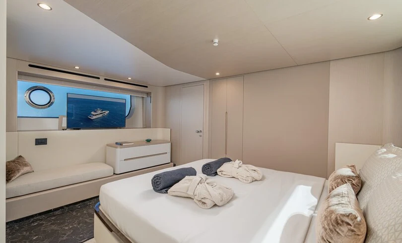 a bedroom with a bed and a tv on the wall aboard SBK Yacht for Charter